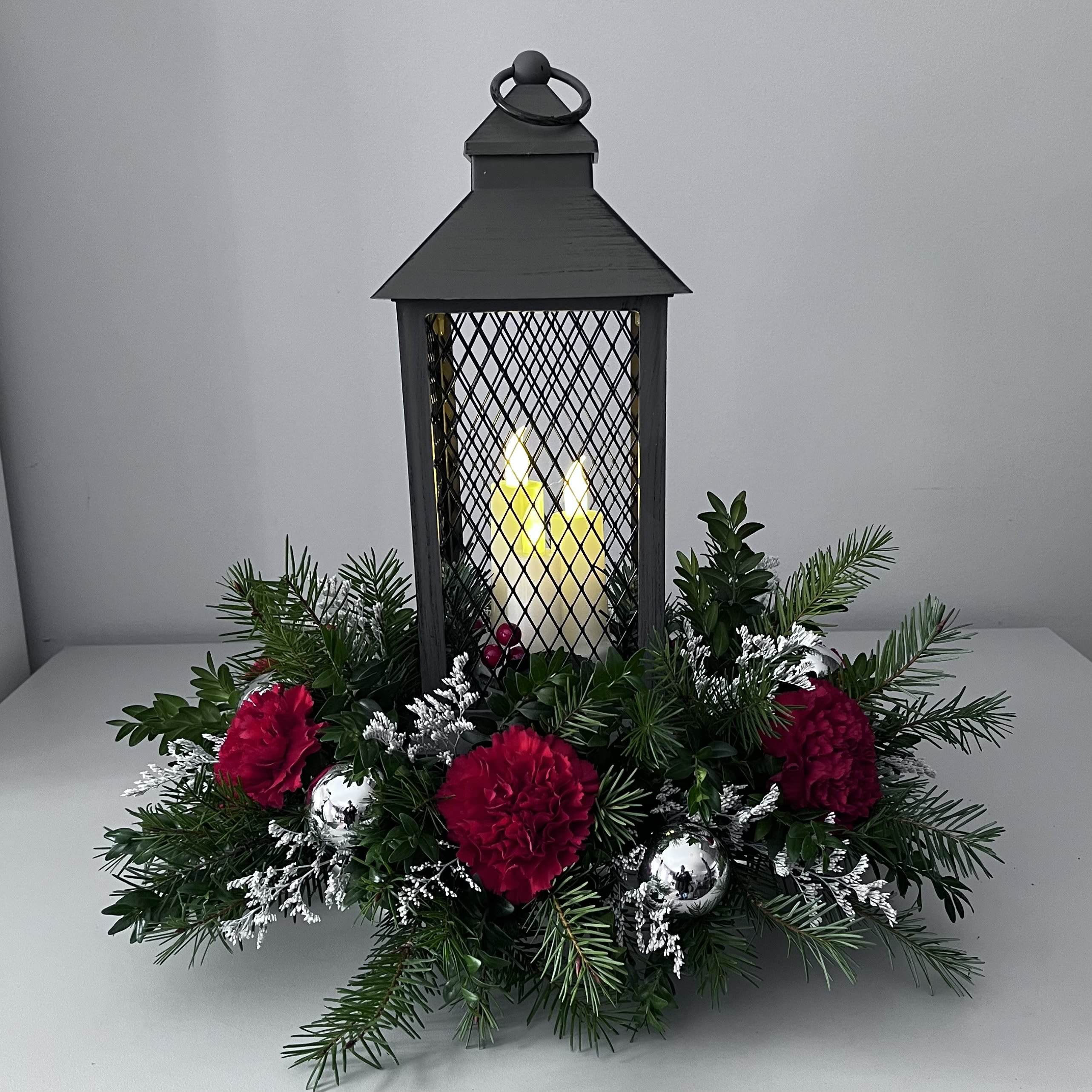 Light the Night - Lantern Centerpiece with fresh seasonal greens, Carnations and fillers  