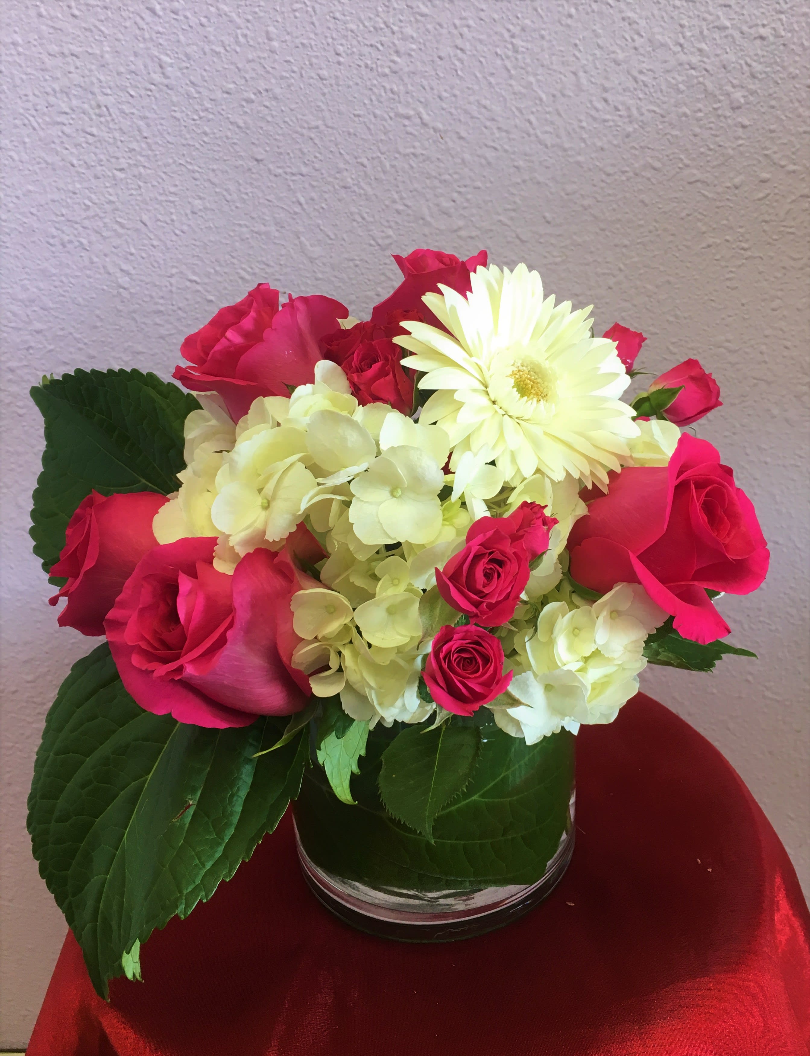 Flirty in Pink by Forever Flowers - Arrangement Details: Includes hot pink roses, pink spray roses, and white hydrangea. APPROXIMATE DIMENSIONS: 12" H X 11" W 