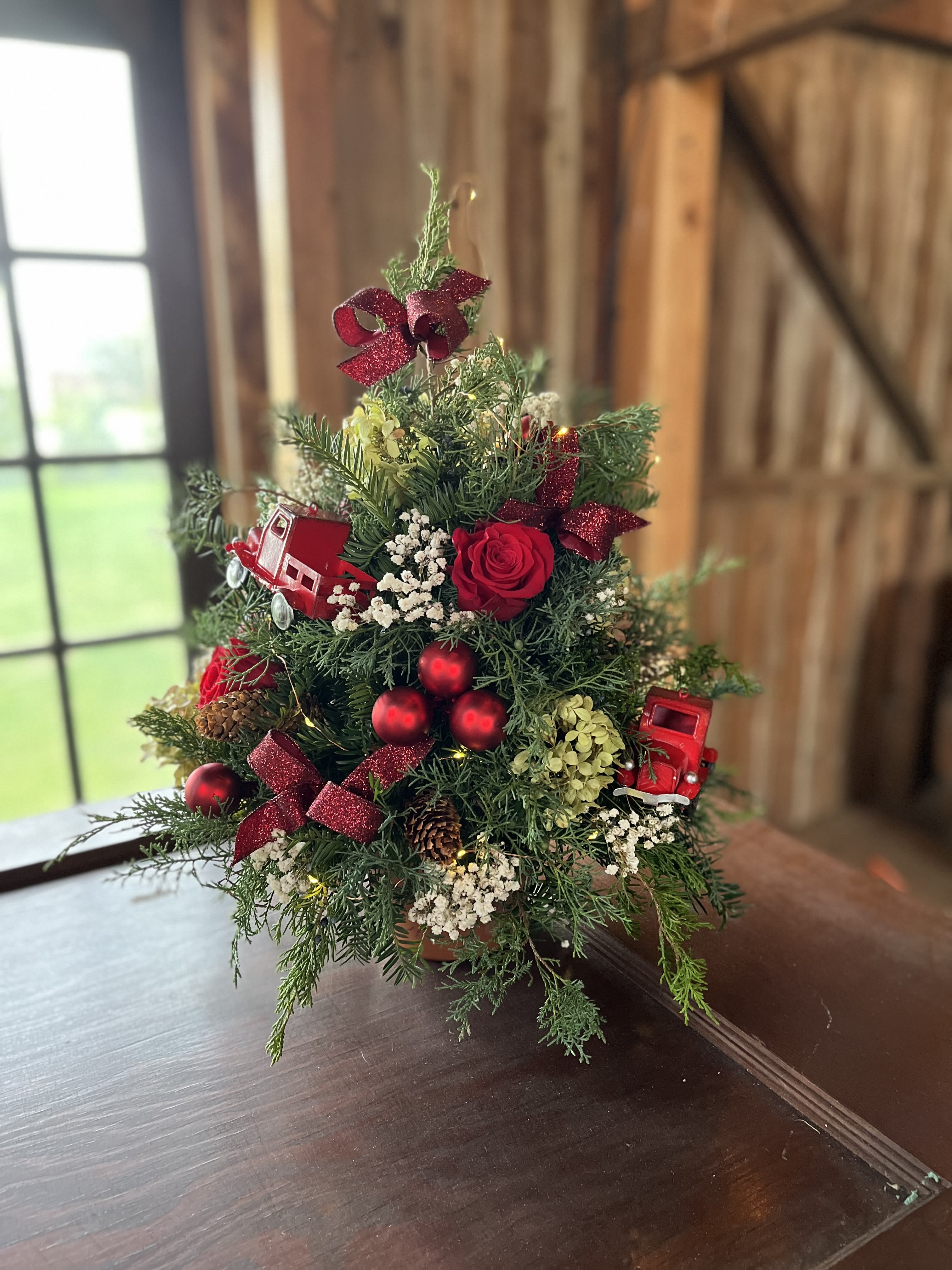 I'll be home for Christmas - A classic festive Christmas tabletop tree adorned with fresh flowers, bows and baubles to share with your loved one during the holiday season  