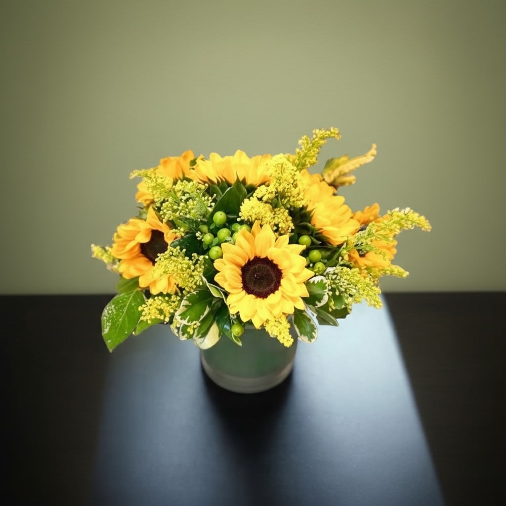 Sunflower Field - Send this bright and beautiful design to cheer up your friends day. Design includes sunflowers, green berries, green and yellow accents in a cylinder vase 