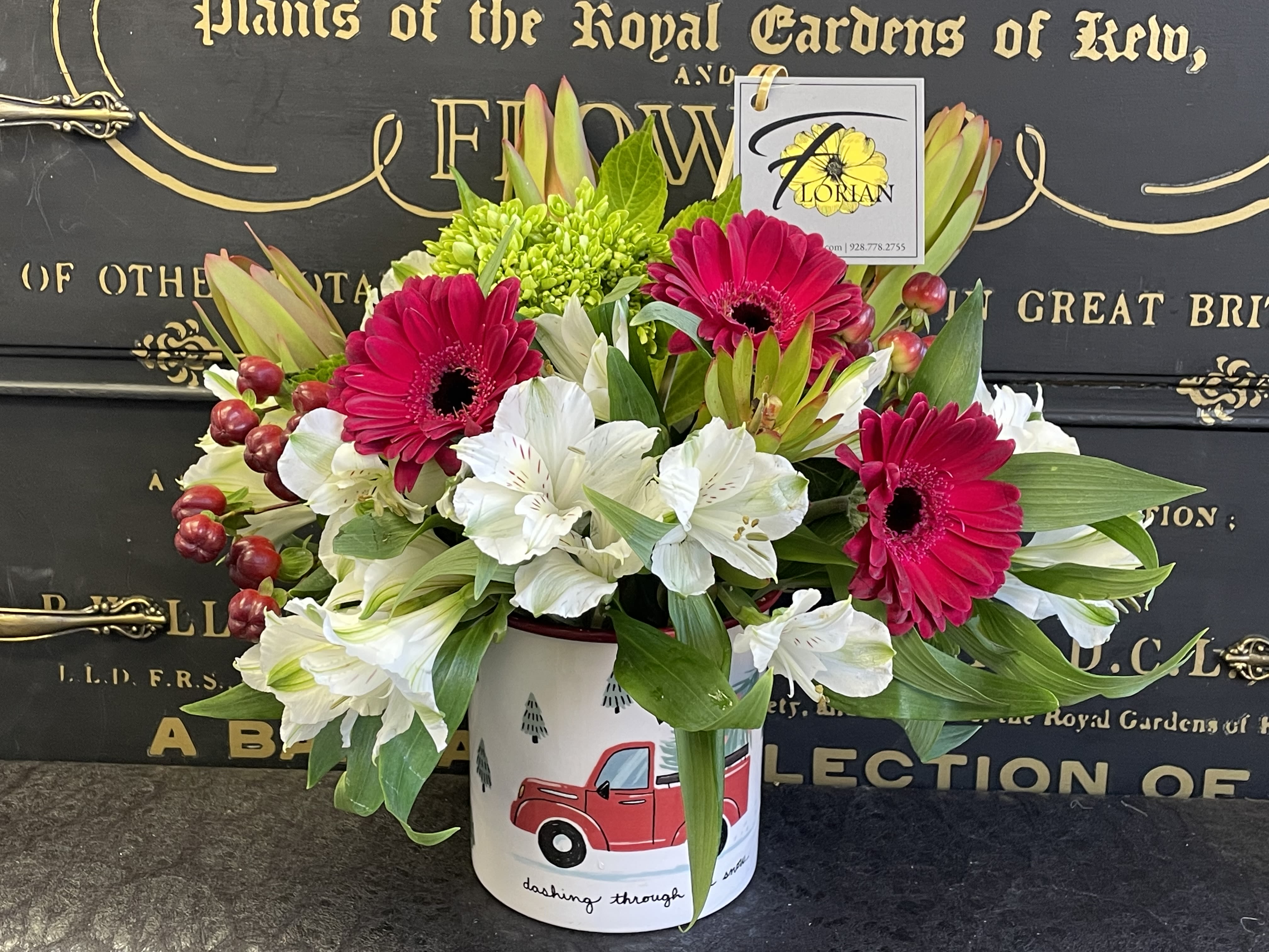 Truckin' through the Snow - This guy is sure to draw a smile with its classic red truck camper mug style filled with alstroemeria, red mini gerbera, and more! This container is limited supply-once they're gone, they're gone! 