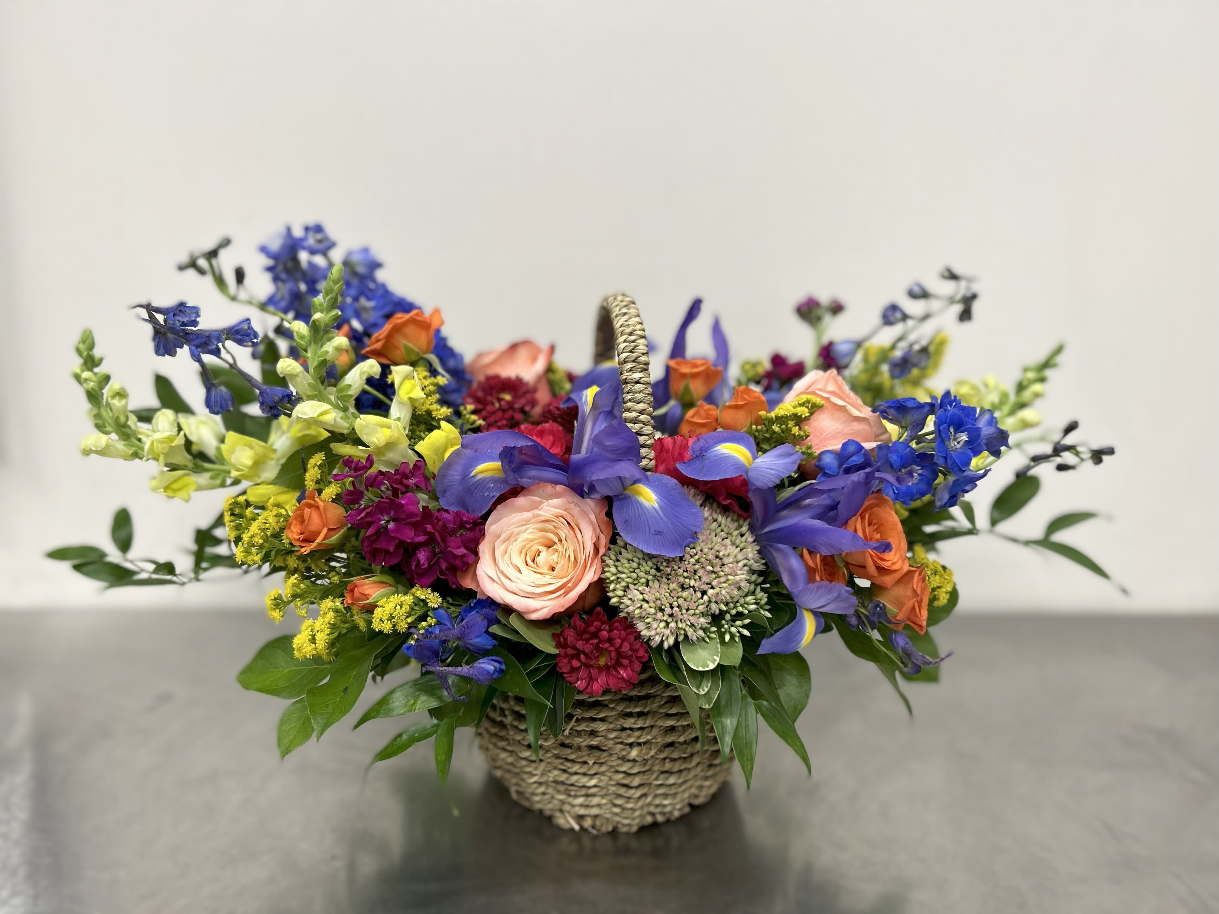Mondrian Basket - Classic garden basket with a primary color palate including kahala roses, snap dragons, orange spray roses, iris and delphinium.  