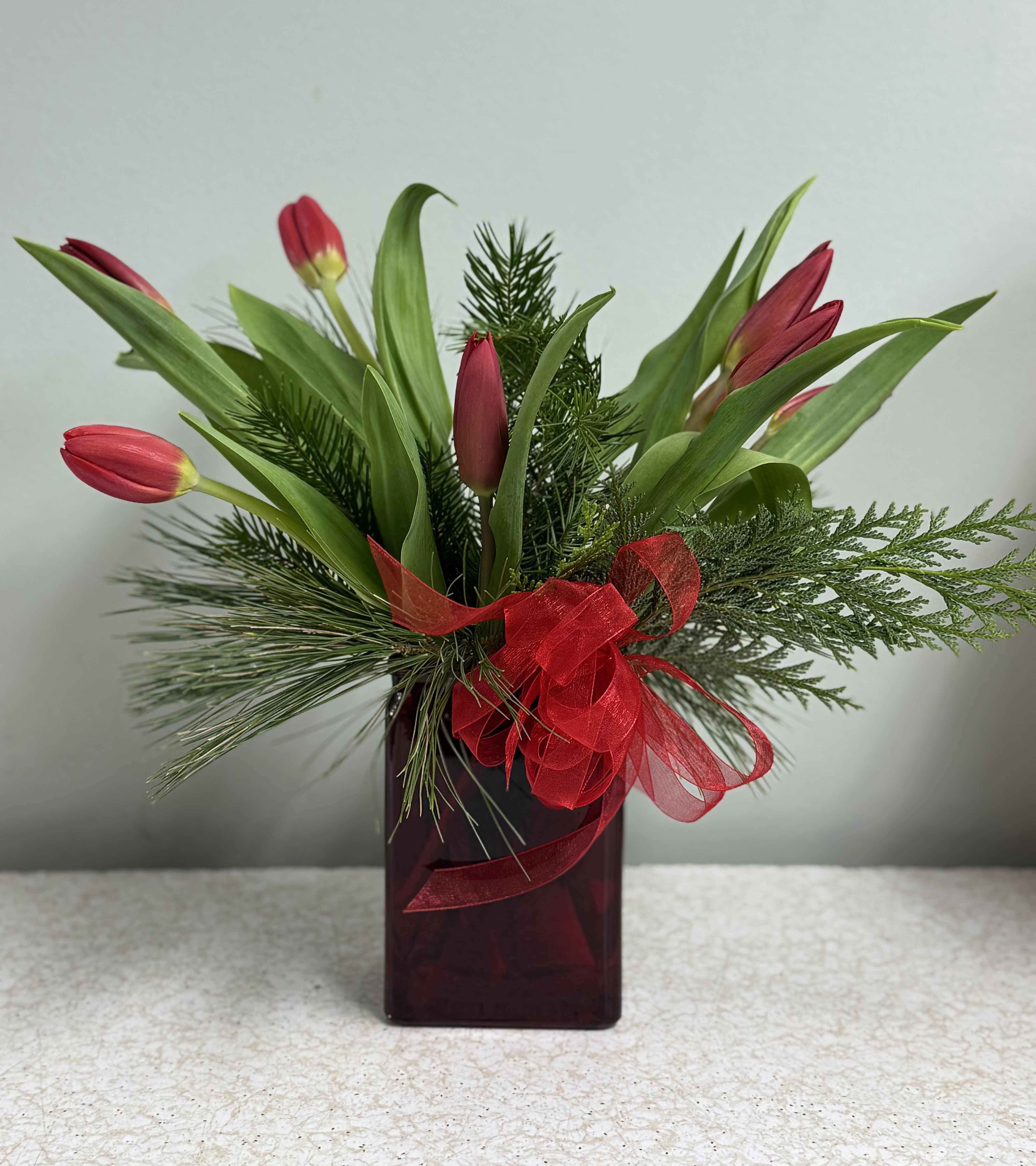 Two-Lips Bouquet, Christmas Edition - Modern and simple, this arrangement consists of eight tulips in seasonal colors with winter greens, in a red rectangular vase, and small bow. Classy and modern.