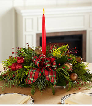 Christmas Callings Holiday Centerpiece - The Christmas Callings Holiday Centerpiece offers a classic holiday style that speaks to the heart of the yuletide season. Bringing together bright green cedar at the base accented with golden pomegranates and red holiday berries, as well as, a traditional English red and green plaid bow, this centerpiece is sure to bring light and love to any holiday gathering. Arranged to surround a singe 7-inch red tapered candle, this gorgeous centerpiece will be that perfect accent piece for your Christmas table or create a great gift for friends and family across the miles. Your purchase includes a complimentary personalized gift message.