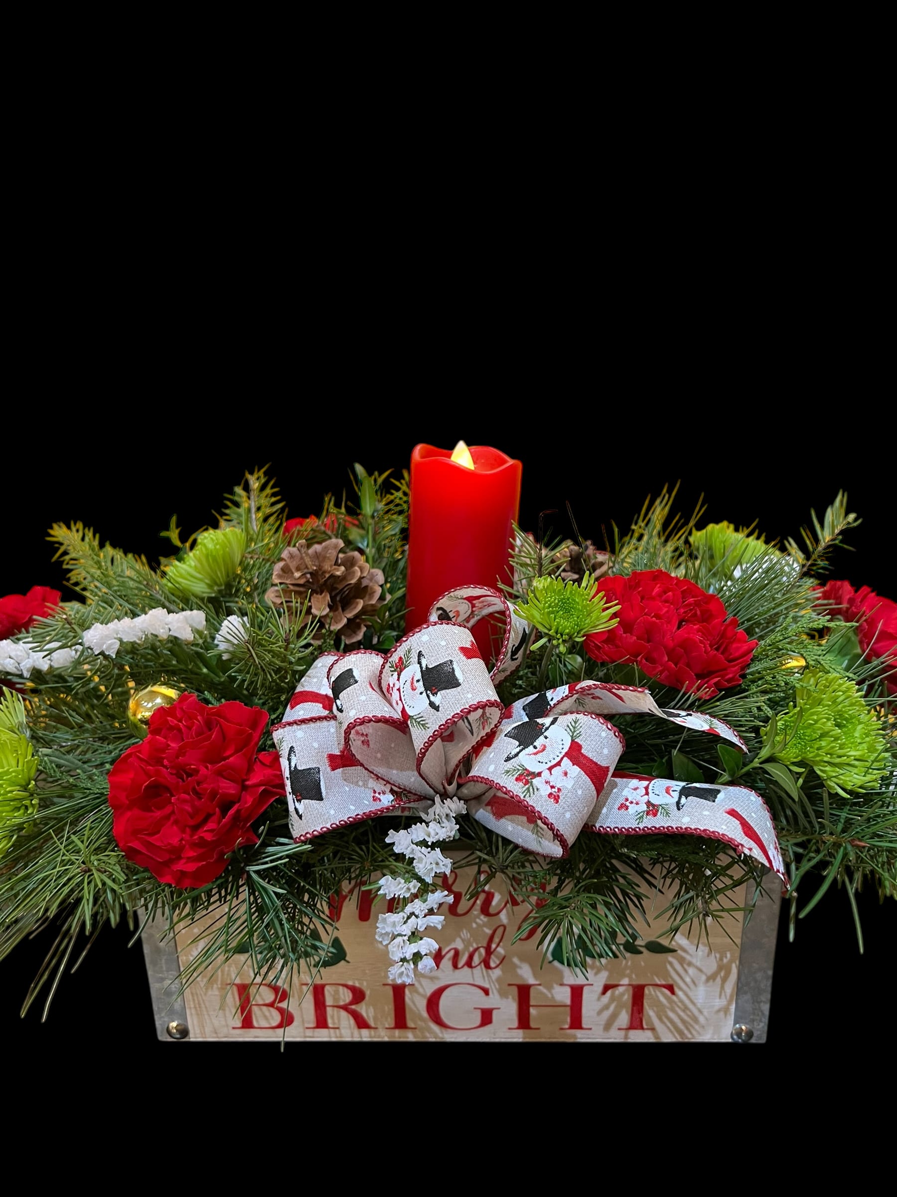 MERRY &amp; BRIGHT CANDLE CENTERPIECE - Traditional flowers, cones, ribbons, etc. designed centerpiece style in our Bright &amp; Merry wood box. Contains a battery operated candle keepsake gift!