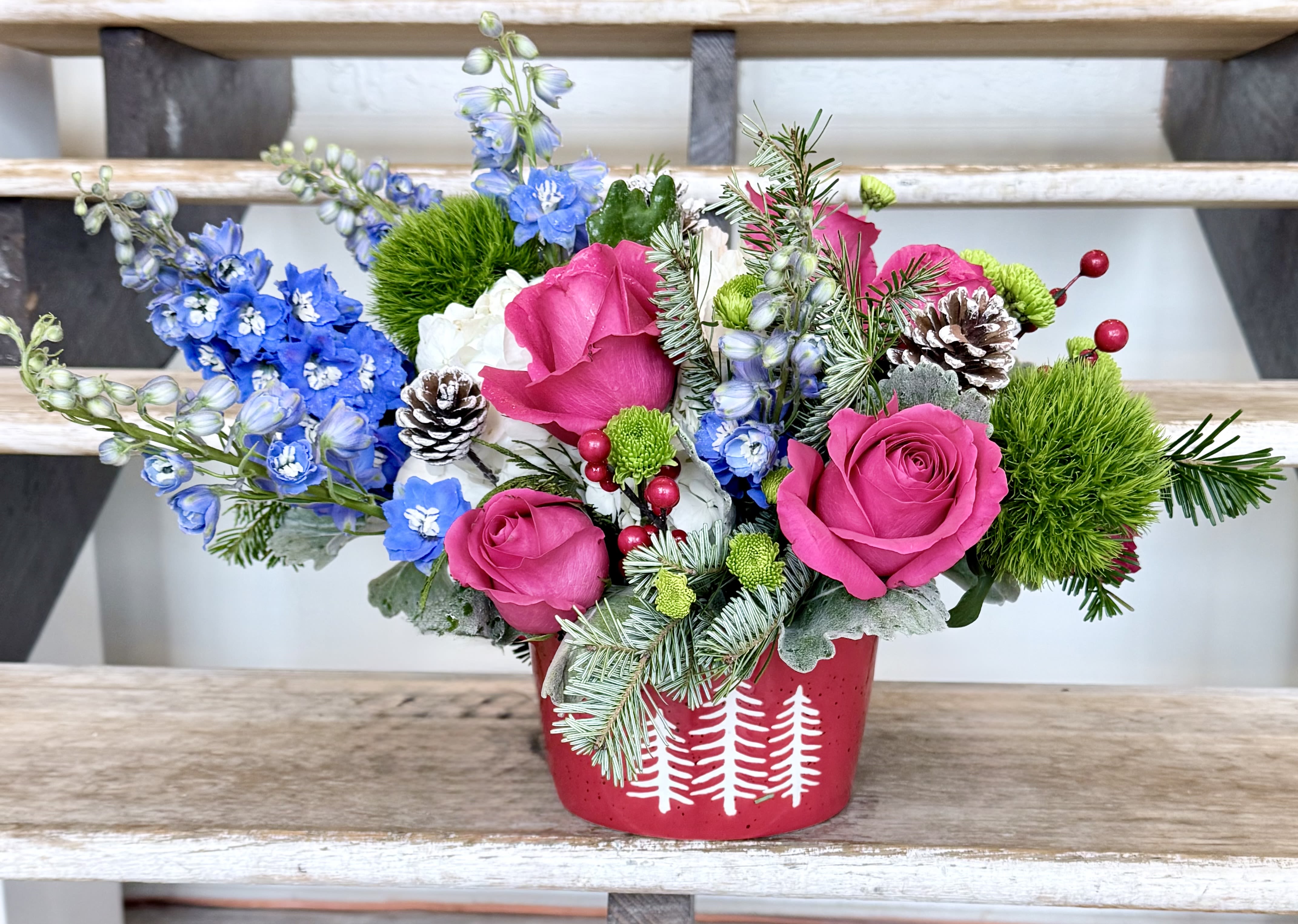 Winter Wonderland Centerpiece  - A winter whimsy centerpiece brings festive cheer to your table, counter, or desk with red and/or hot pink Roses, blue Delphinium, Hydrangeas, green Dianthus, berries, and frosted pine cones. Arranged in a dish-perfect (a real casserole/baking dish keepsake container) with fresh evergreens for Christmas or winter gatherings. 
