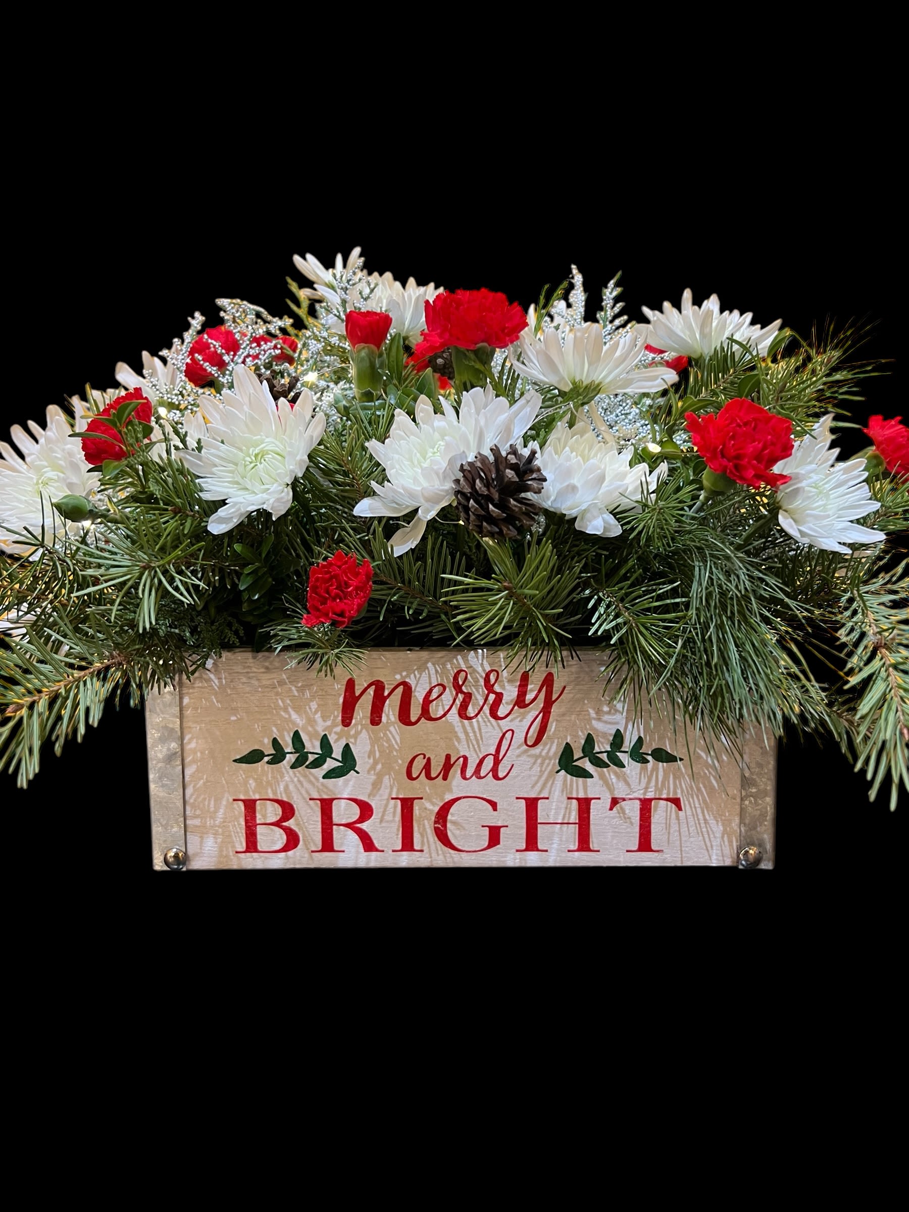 Merry &amp; Bright Lights Centerpiece - Our own design - mixed winter greens, traditional carnations and mums, etc. Also contains battery operated lights in a festive wood container.
