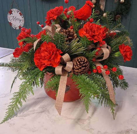Cardinal in the Pines - Celebrate the beauty of winter with our Cardinal in the Pines arrangement, designed in a charming cardinal-themed crock that captures the spirit of the season. Lush assorted Christmas greens create a fragrant, textural base, while seasonal Christmas flowers add rich color and festive elegance. A sweet cardinal bird pick perches among the blooms, symbolizing love, hope, and cherished memories. This heartfelt piece brings a touch of woodland magic to any home and makes a thoughtful gift for the holidays.