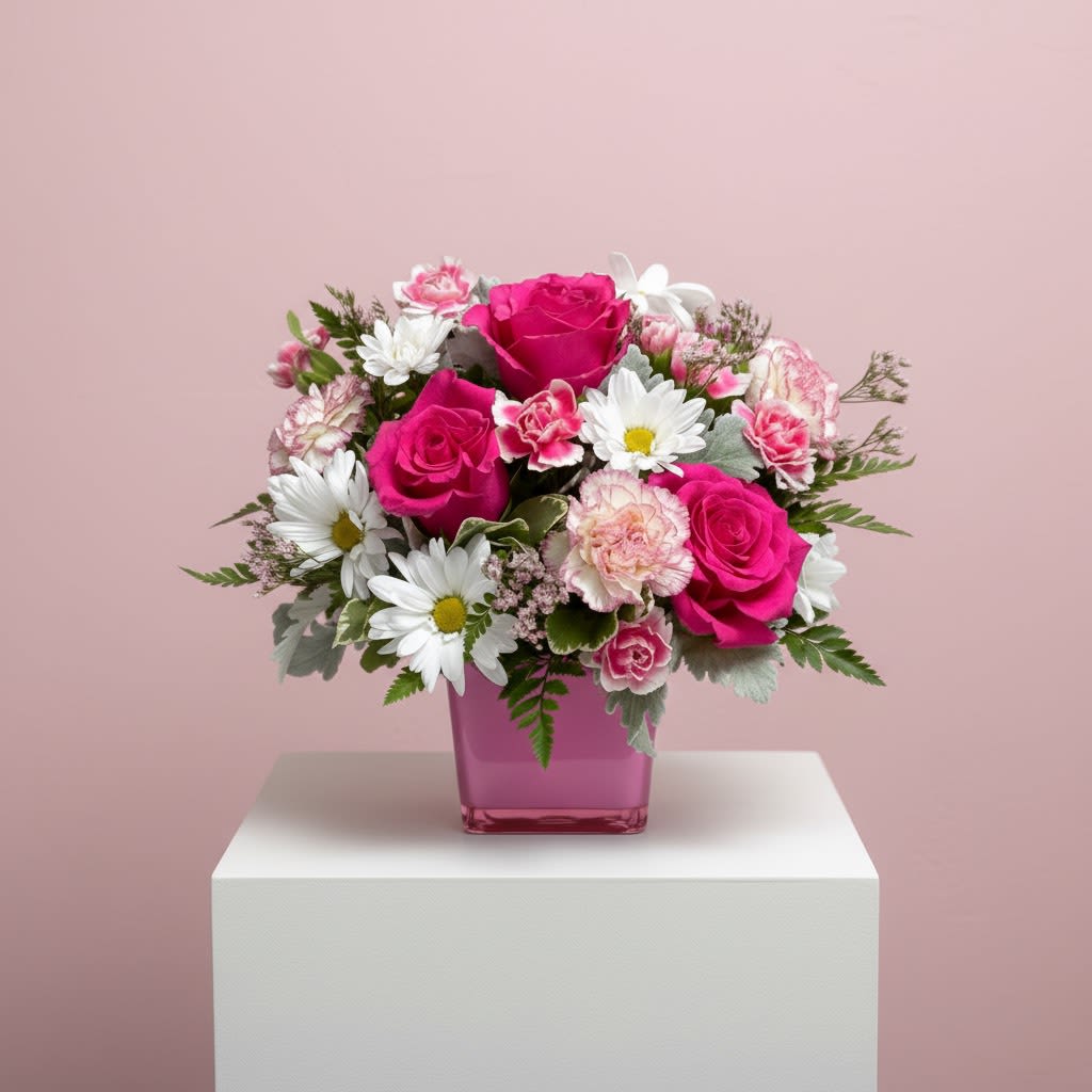 Daisy Kisses - Vibrant mix of fuchsia roses, pink carnations, and white daisies in a pink cube vase.   Approx. 10" H x 10" W.