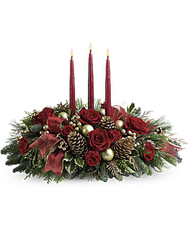 All is bright PLUS - All is calm, all is bright…well, at least we can promise the latter with this luminous arrangement! Gather family and friends together for a holiday meal around this traditional Christmas centerpiece featuring pinecones, holly, noble fir and Christmas candles. 'Tis the season to shine! A fresh centerpiece of holly, noble fir, white pine, flat cedar, roses and spray roses is decorated with golden berries, Christmas ornaments, pinecones and three red taper candles. A sheer, gold-edged organza ribbon adds to the opulence.