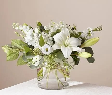 Alluring Elegance - An illuminating array of florals brings an air of elegance to any room it's placed. This arrangement features refined florals like lilies and stock in a glass vase to add a touch of sophisticated style to your special occasions. 