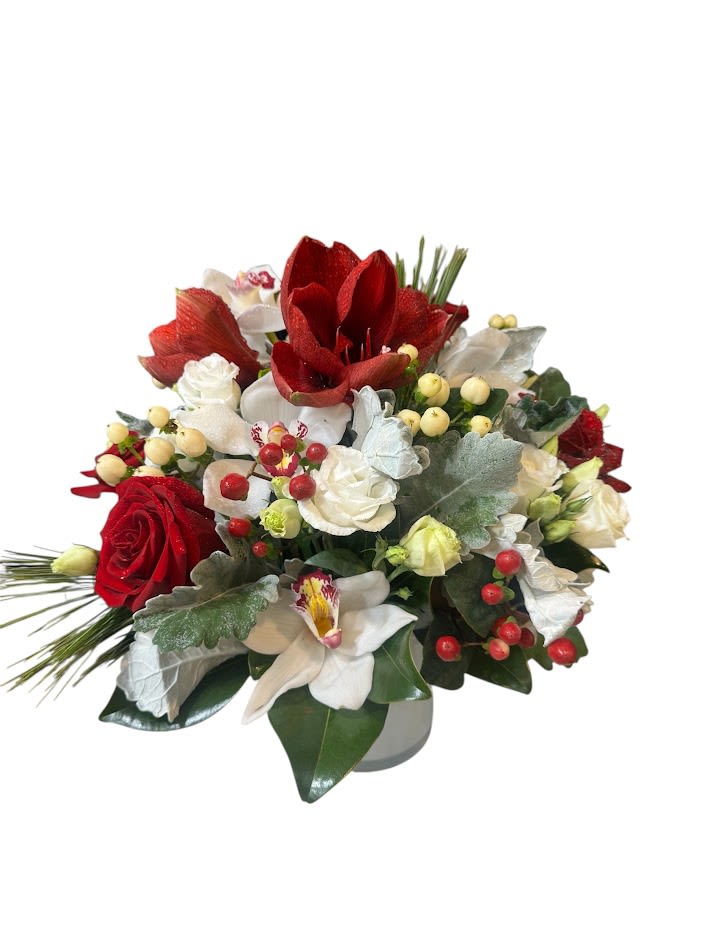 Amaryllis Bouquet - Amaryllis, Roses, Orchids with holiday greeneries in a clear vase Flowers that are high quality, fresh, and beautiful. While we may seasonally need to substitute for flower variety also we may sometimes need to use a different vase or different greens for sub material.