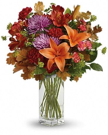  Fall Brights Bouquet - Brighten any fall day with this colorful array! Gorgeous orange lilies arranged with red and lavender blooms are sure to make someone smile! This lovely bouquet includes orange asiatic lilies, dark orange alstroemeria, red carnations, orange miniature carnations, lavender disbud chrysanthemums, bupleurum, lemon leaf and oak leaves. Delivered in a beautiful clear Bunch vase.