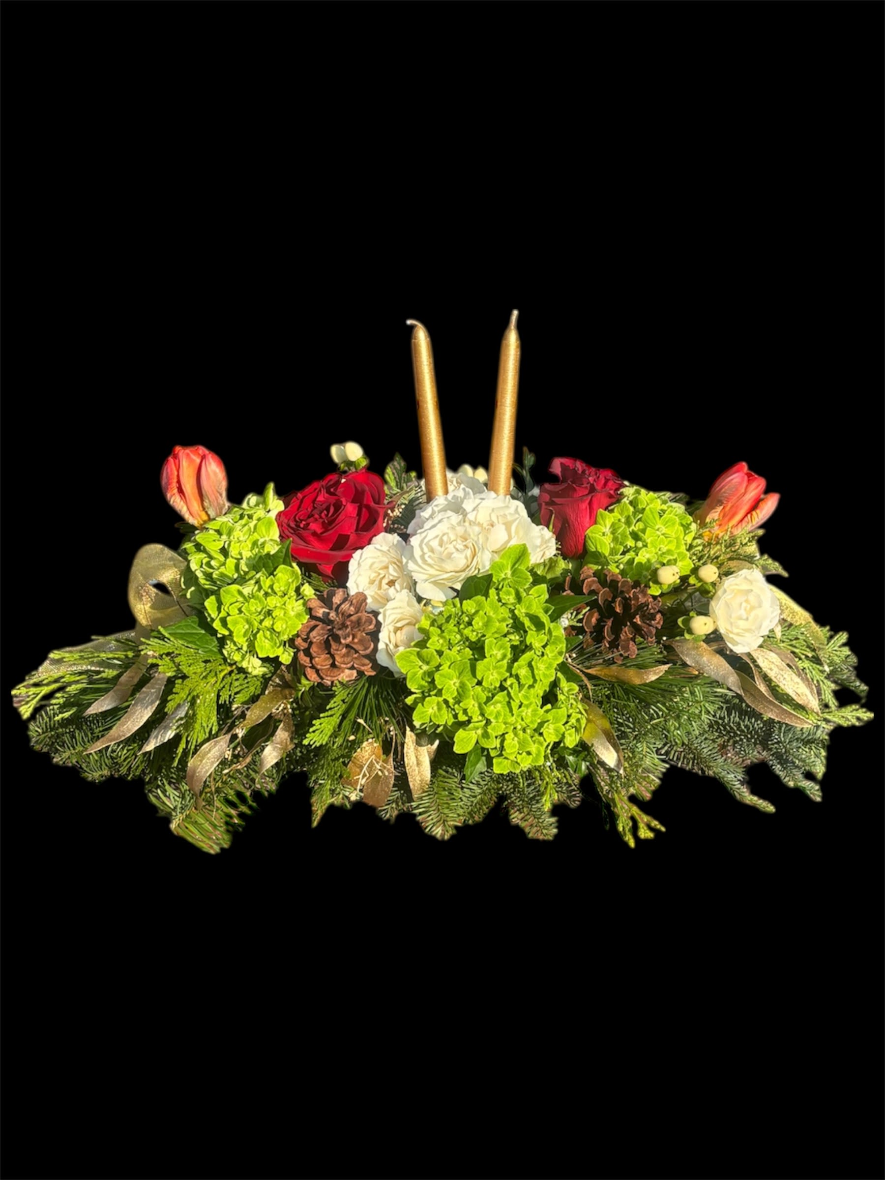 Crystals and Candles - A festive container arrangement featuring lush green hydrangeas, radiant red roses, striking red parrot tulips, delicate white spray roses, and elegant white hypericum. Accented with a mix of winter greenery, shimmering gold-leaf pinecones, and completed with two gold candles, this design brings together the sparkle of crystals with the warmth of the season for a truly enchanting holiday centerpiece.