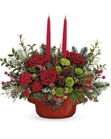 Christmas Hearth Centerpiece - Create the perfect holiday atmosphere with our Christmas Hearth Centerpiece, a warm and elegant arrangement designed to elevate any Christmas table. This stunning centerpiece features rich red roses, festive red carnations, and vibrant green button mums, beautifully accented with winter evergreens, frosted pinecones, and bright red berries. Two taper candles rise gracefully from the center, adding a soft, glowing ambiance that transforms any room into a cozy Christmas retreat.  Arranged in a charming red ceramic bowl reminiscent of a holiday hearth, this design blends traditional Christmas elements with upscale floral artistry. It’s ideal for Christmas dinners, holiday parties, or simply bringing festive beauty into your home décor. The combination of textures—lush florals, natural greens, and seasonal accents—creates an eye-catching, full arrangement perfect for any holiday setting.  Handcrafted with care by Miami Flowers Design, this centerpiece is a top choice for customers looking for luxury Christmas arrangements, holiday table décor, or same-day Christmas flower delivery in Miami. Add warmth, elegance, and seasonal cheer to your celebrations with this unforgettable holiday centerpiece.