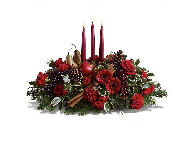Joyful &amp; Triumphant - Bring the bountiful joy of the season home to the holiday table with this magnificent harvest-themed candle centerpiece, featuring an abundance of garden elements, arranged with fresh flowers and evergreens around three tall red tapers. A beautiful way to create a new tradition this year  Red roses, gerberas and carnations – accented with faux grapes, pears and a pomegranate, plus pinecones, cinnamon sticks and mixed evergreens - are arranged in a dish around three red taper candles. Approximately 25&quot; (W) x 16&quot; (H)