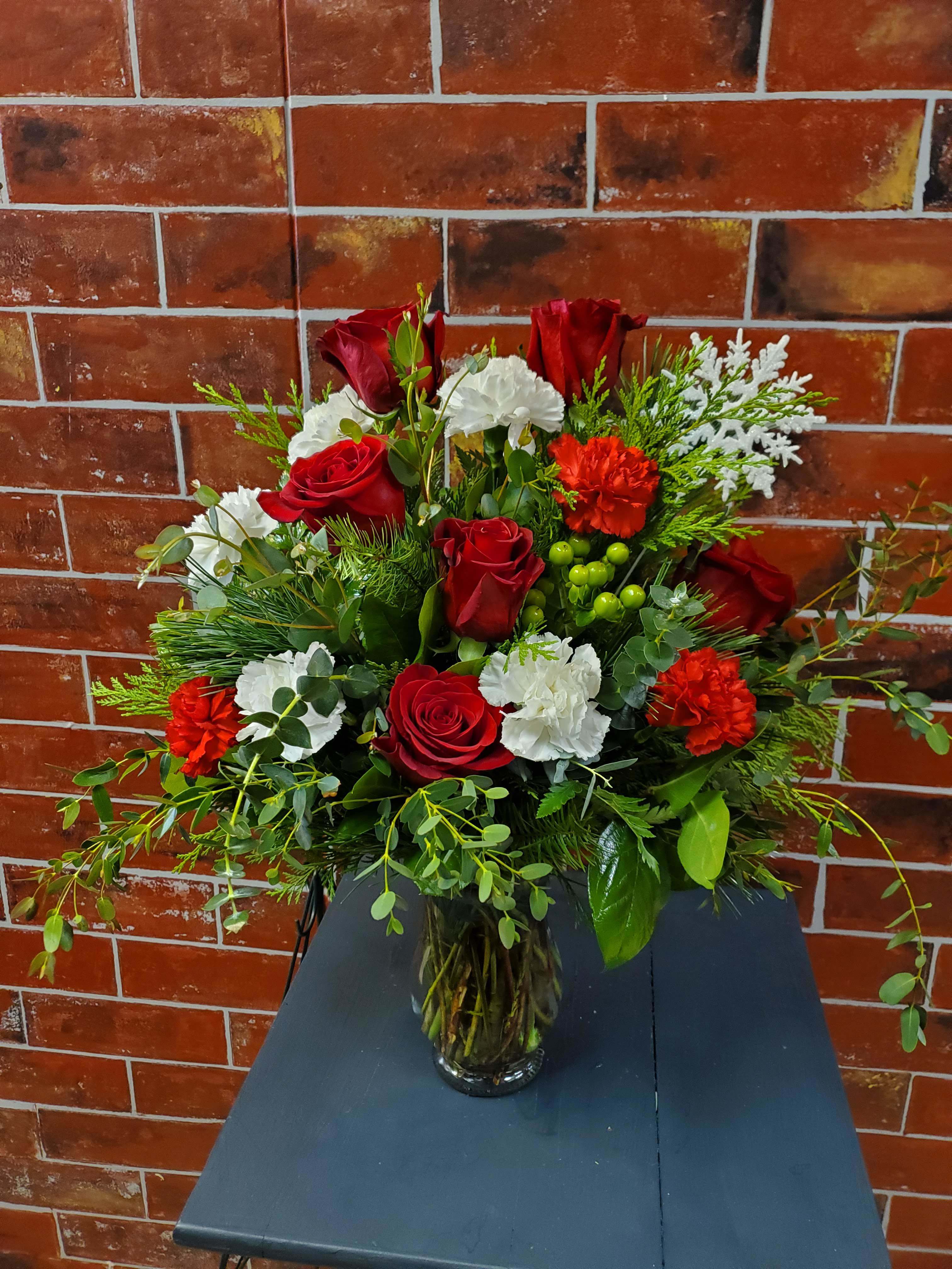 Snowflake Christmas - This design has red roses, white and red carnations and greenery.  *Some stages of flower life may vary. (Example: Lilies may be more open than imaged.)  Flower shortages and product availability means that some substitutions will apply. Value will always be filled.  This bouquet might include eucalyptus amongst the greenery. It may be toxic to pets including but not limited to Cats and Dogs if digested.