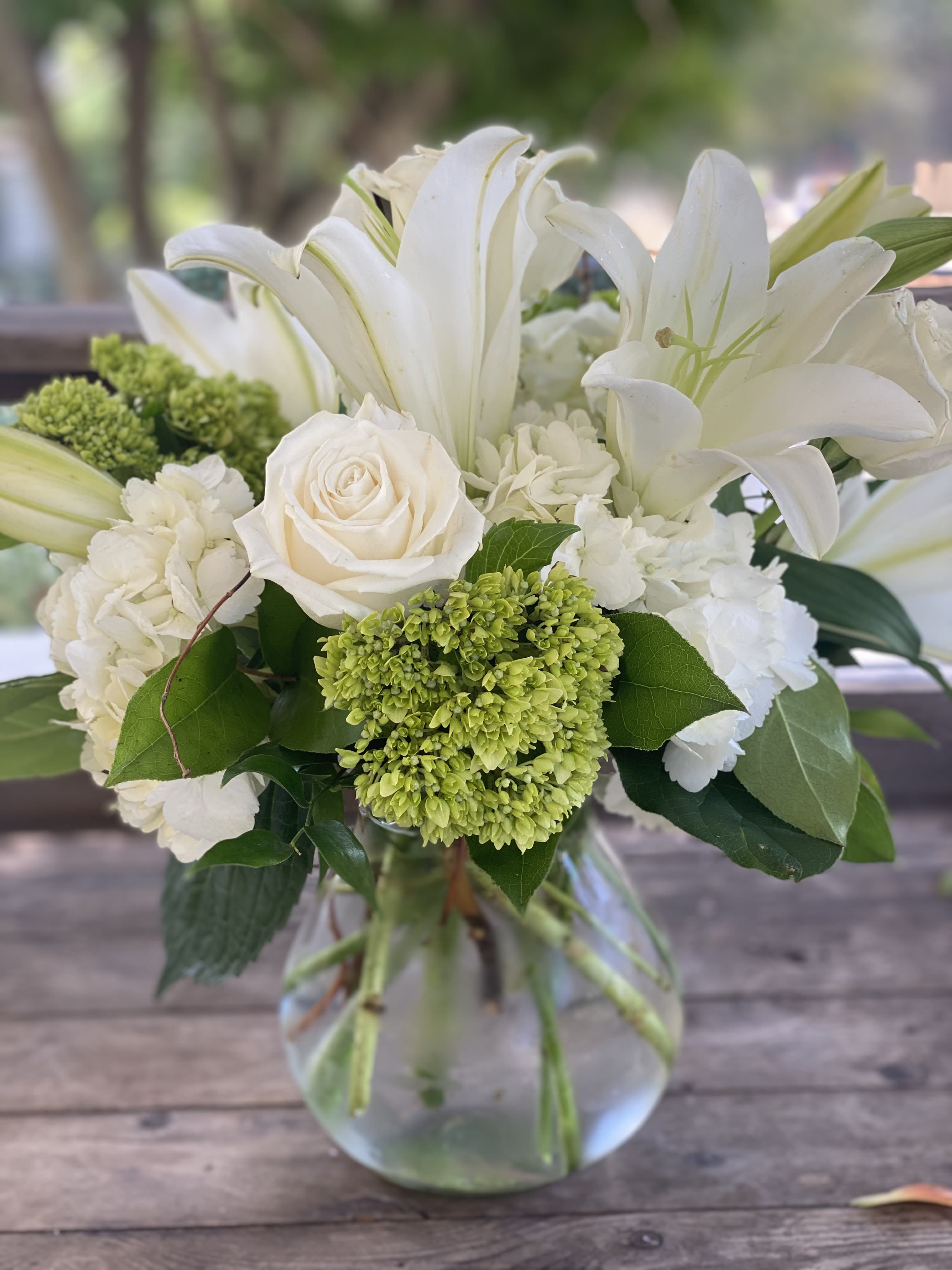 Serene Fondness - Express Your Purest Emotions with Tranquility Our "Serene Fondness" arrangement is designed to convey your purest feelings through a tranquil selection of cool-colored, fresh garden flowers. This bouquet embodies peace and elegance, making it an ideal choice for moments that require a touch of calm and sincerity. **Cool Color Palette: Featuring a harmonious blend of creams, greens, and whites, this arrangement evokes a sense of serenity and peace. **Fresh Garden Blooms: Each flower is carefully selected to ensure freshness and longevity, enhancing the bouquet's natural beauty. **Meaningful Gesture: Perfect for expressing sympathy, gratitude, or affection, this arrangement communicates heartfelt emotions with grace. Choose "Serene Fondness" from Elizabeth's Garden to deliver a message of tranquility and sincerity, beautifully captured in a bouquet that speaks from the heart.