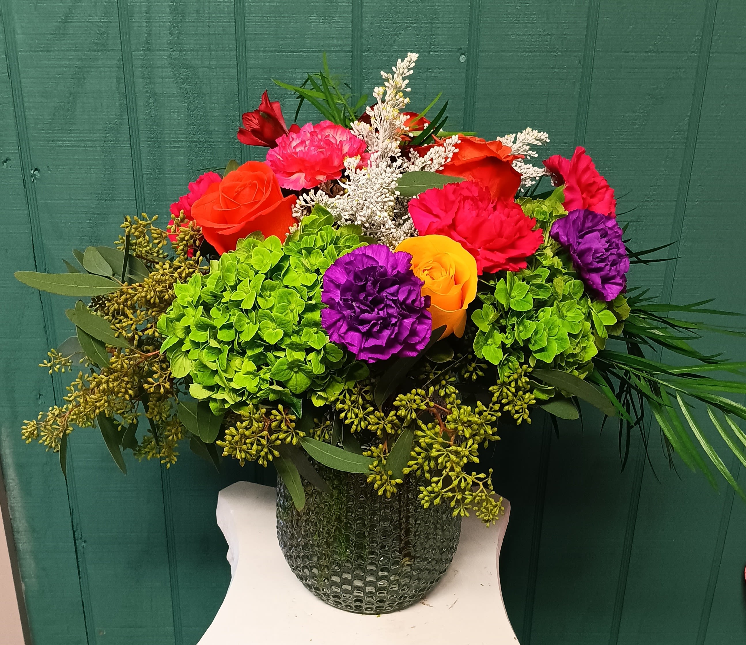 Skittles - A playful explosion of color, the "Skittles" arrangement radiates joy with its bold and vibrant hues. This stunning design features a variety of blooms in every shade of the rainbow, artfully arranged with lush greenery to create a fresh and modern vibe. Presented in a sleek glass vase, this arrangement is perfect for brightening up any space or celebrating life’s most colorful moments.