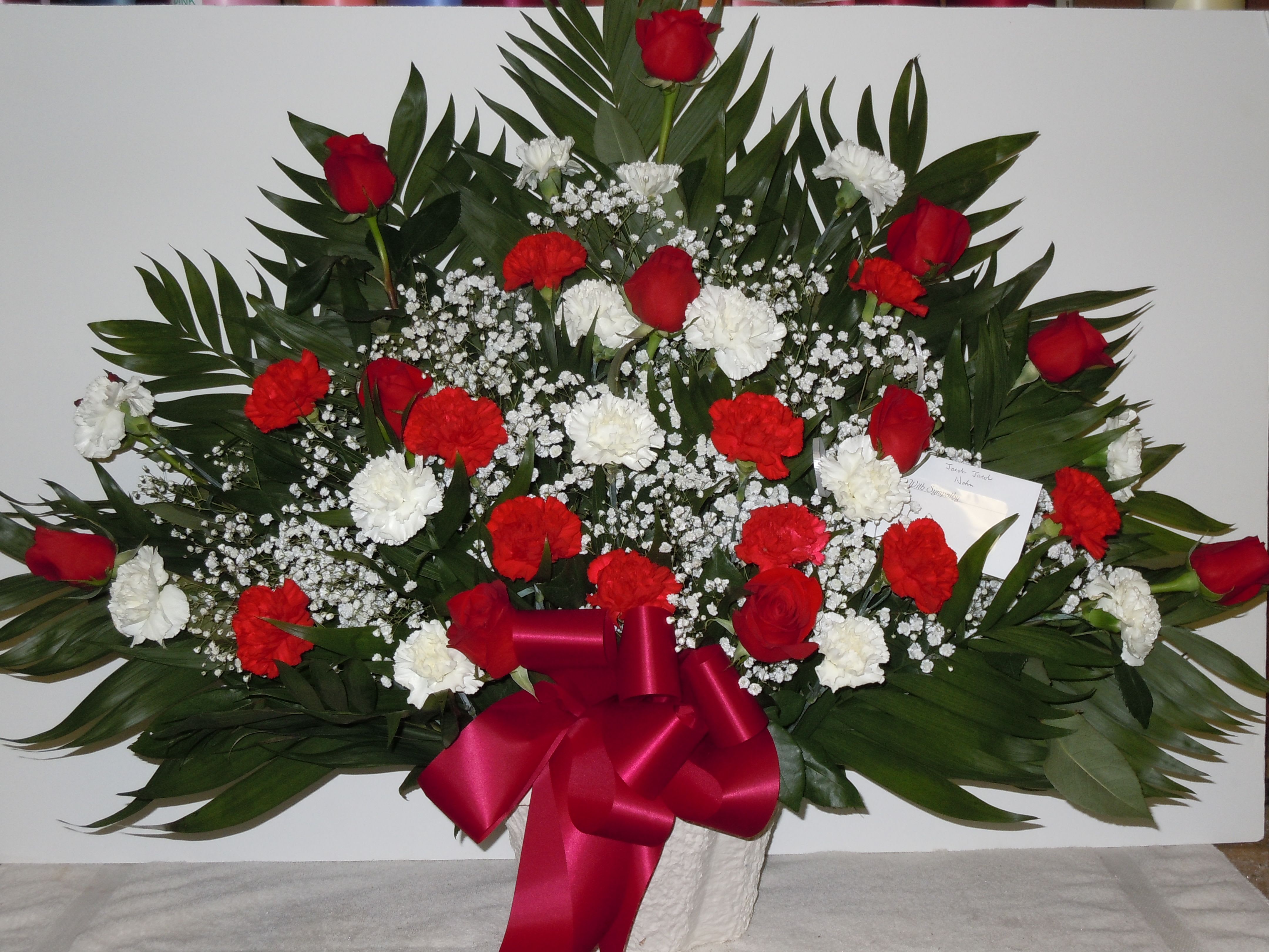 TB5 Traditional Basket - Sympathy mache - includes red carnations, white carnations, red roses, baby's breath, greens, and bow.  Banners not included $15 + per banner   Substitutions may apply pending flower availibilty