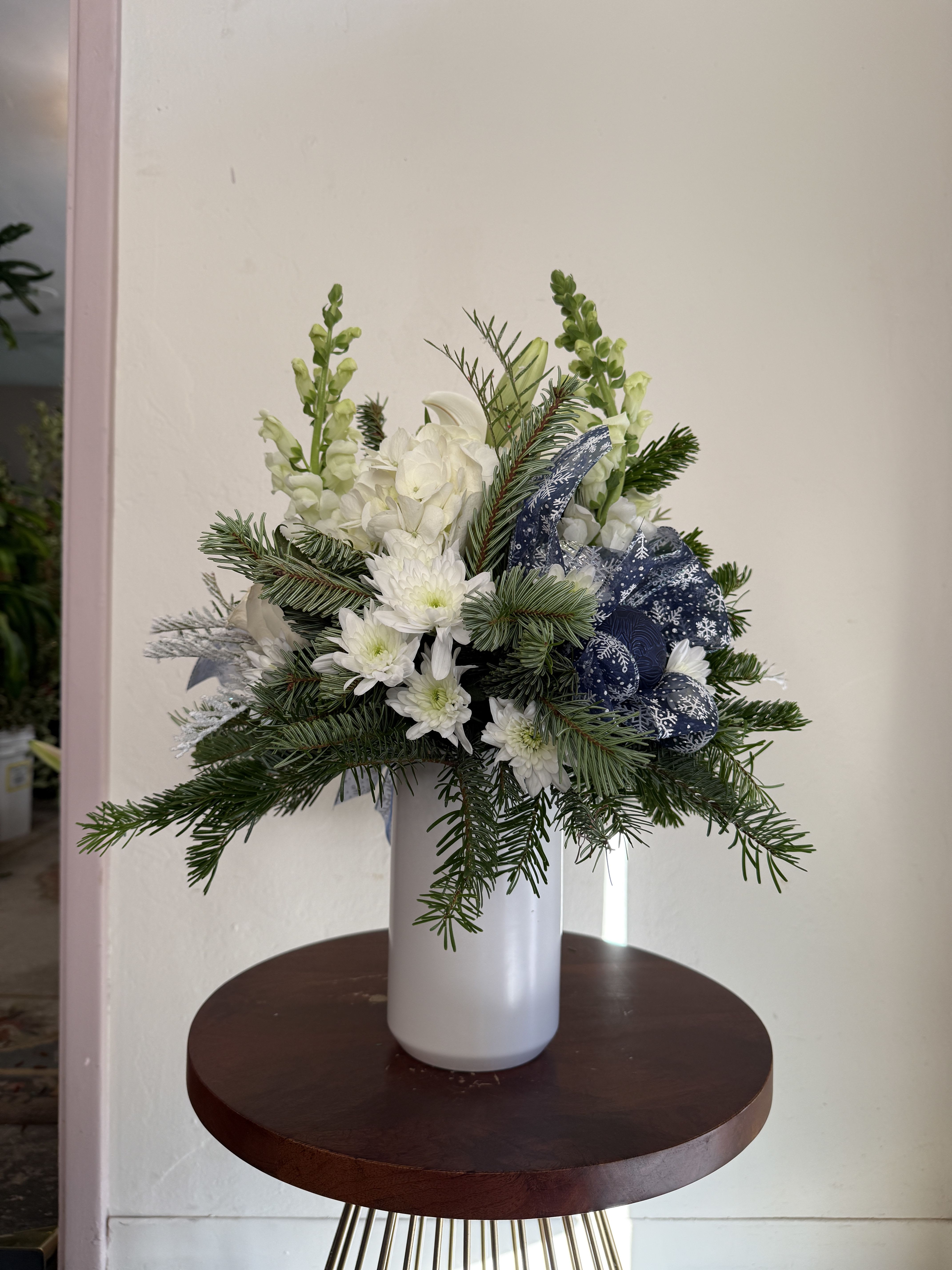 Blue &amp; White Holiday - Variety of blooms, including hydranges, snapdragons, lilies, roses and cushion nestled in christmas greenss adorned with ornaments and ribbon. 