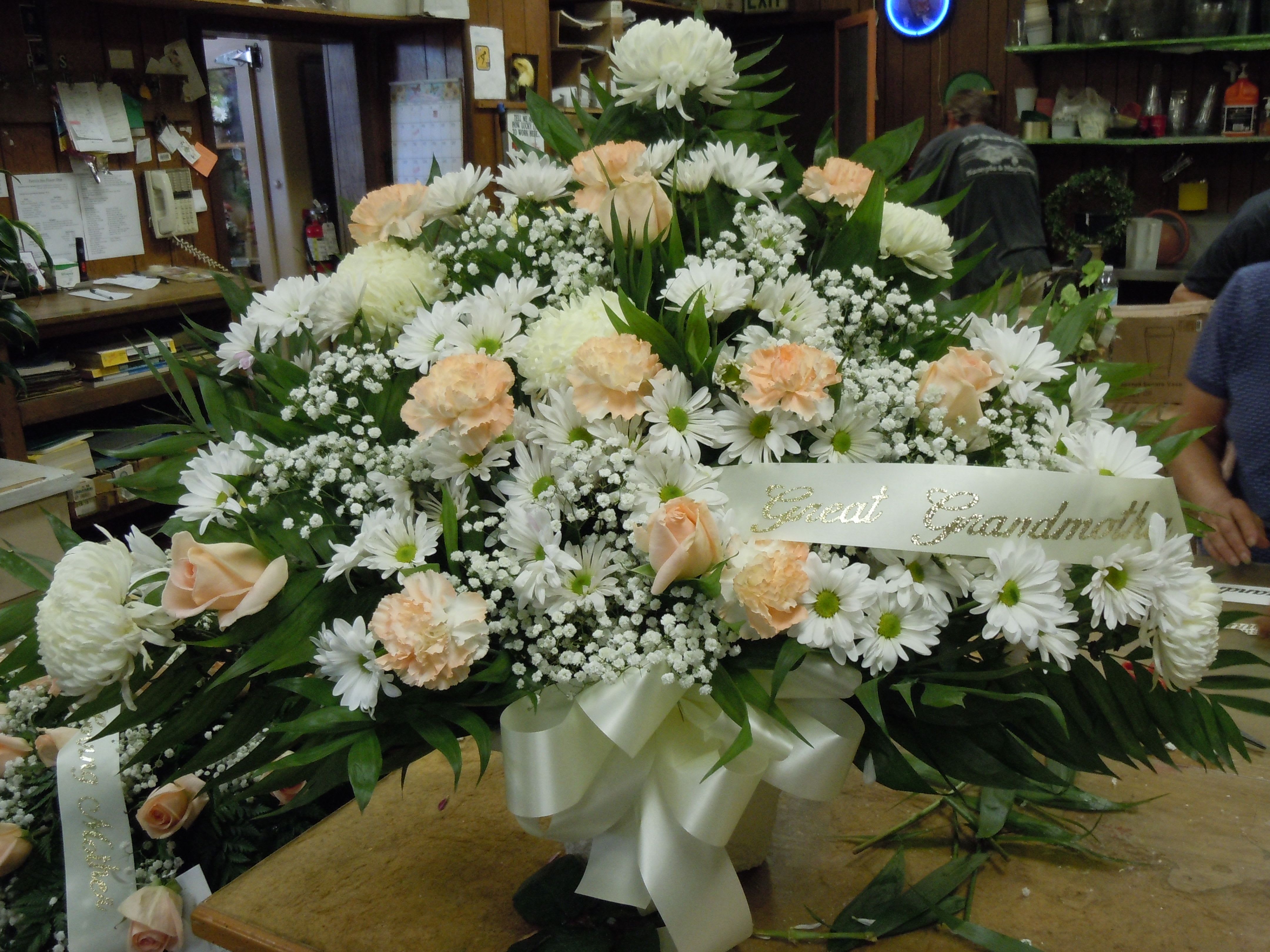 TB8 Traditional Basket - Sympathy mache - includes white spider mums, peach roses, peach carnations, baby's breath, greens, and bow.  Banners not included $15 + per banner   Substitutions may apply pending flower availibilty