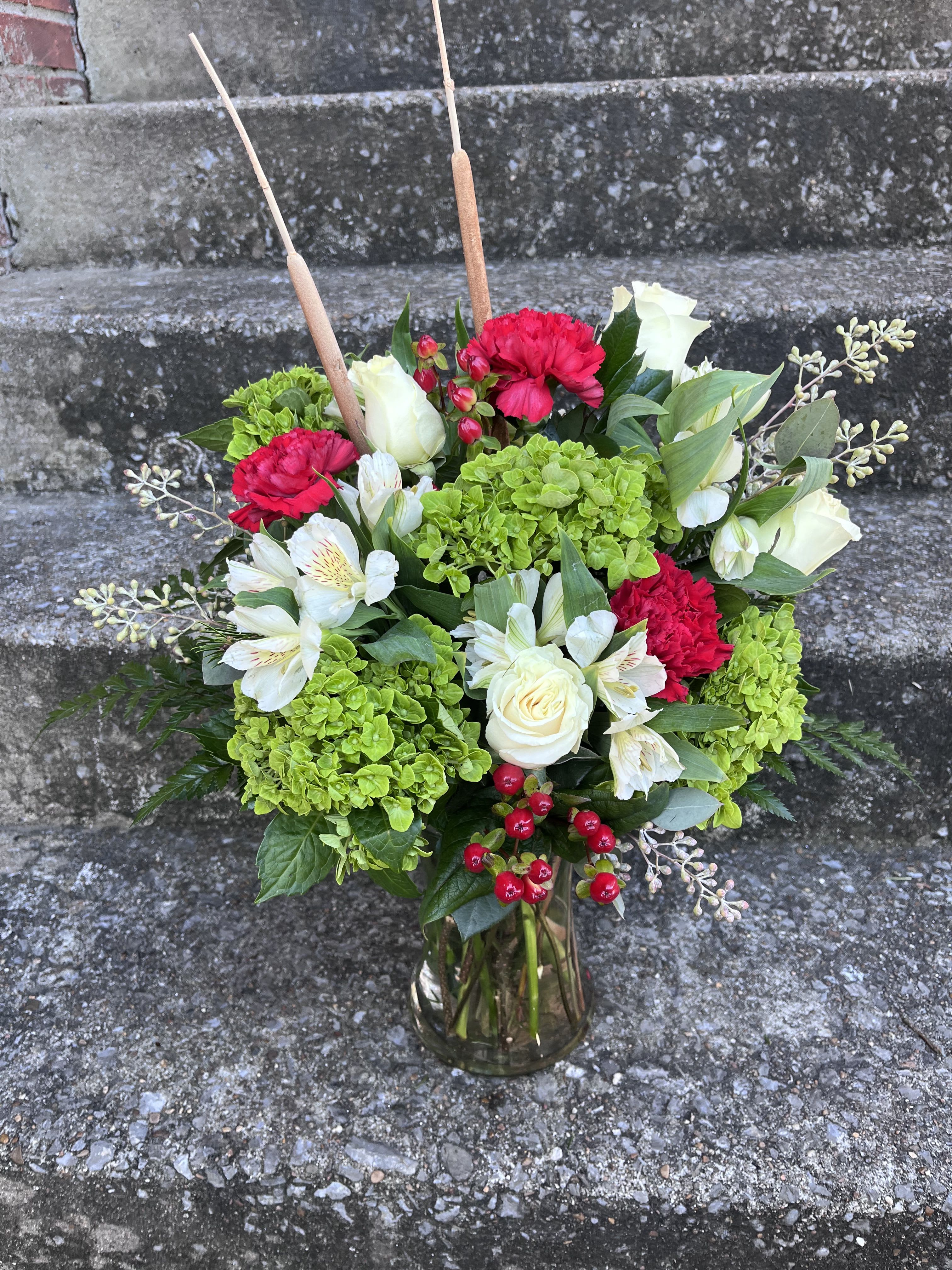 Wonders Of Winter - This arrangement has green hydrangea, Rose’s, Hypericum, alstroemeria, carnations, seeded eucalyptus and Christmas greens.