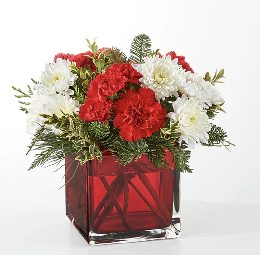 Christmas Market Bouquet - The Christmas Market Bouquet includes assorted seasonal greens to bring the scents of the season to you or your loved ones.  Details The Premium Bouquet is approximately 11"H x 13"W. Designed by florists, ready to display. For long–lasting blooms, replace the water daily. We suggest trimming the stems every couple days. Pet Safety Precautions: This bouquet or plant may include flowers and foliage that are known to be toxic to pets. To keep them safe, be sure to keep this arrangement out of your pet's reach.  Bloom Details Carnation Christmas Greens Rose 