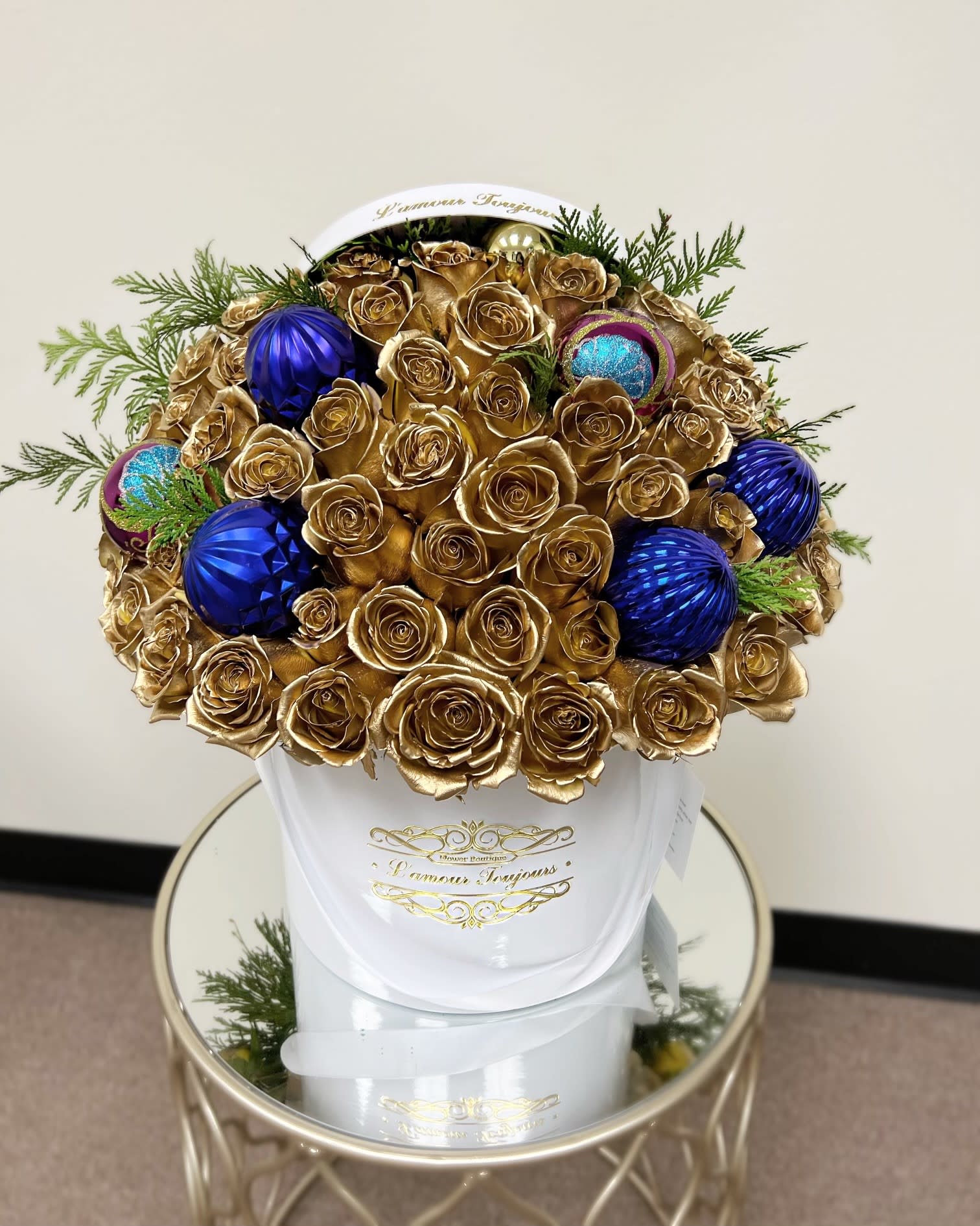 Golden Christmas Flower Box - 50 Gold painted roses with blue Christmas ornaments and fresh Christmas tree branches  in our Signature Box 