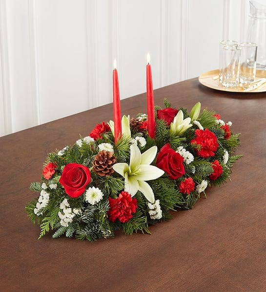 Traditional Christmas Centerpiece - Our traditional table arrangement creates the perfect centerpiece for your Christmas celebration. Beautifully designed with long-lasting blooms in seasonal colors, this fragrant gathering features red taper candles to cast a warm, cozy glow throughout the holidays.
