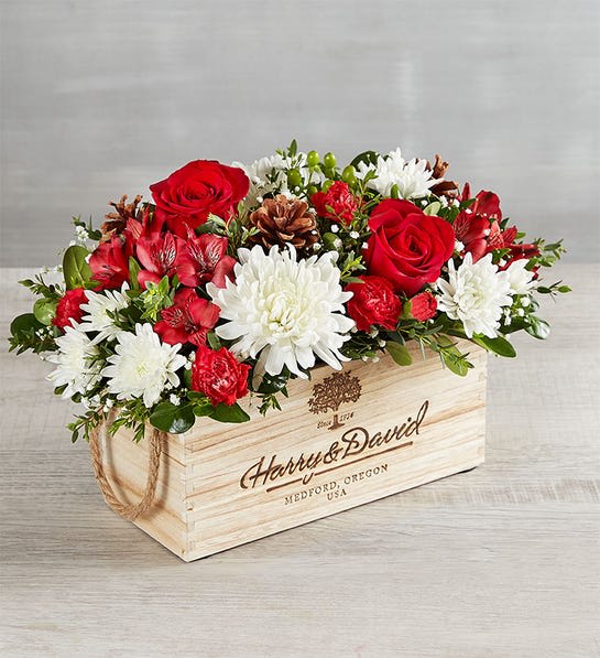 Holiday Gathering Centerpiece - An exclusive centerpiece that celebrates the spirit of giving and holiday gatherings. Overflowing with bright blooms in the season’s signature colors—and some charming, rustic touches—its unique, cascading shape makes it perfect for celebrations. 