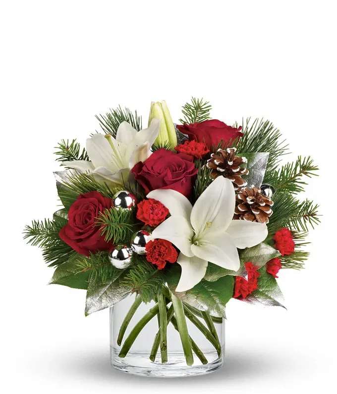 Frosty Forest Bouquet - Make the season sparkle with this festive arrangement of rich red roses, elegant white Asiatic lilies, and cheerful red mini-carnations. Accented with fresh seasonal greenery, shimmering silver ornaments, and frosted pinecones, this bouquet is presented in a clear glass vase for a sophisticated holiday gift or centerpiece.  Includes: • Red Roses • White Asiatic Lilies • Red Mini-Carnations • Seasonal Greens • Silver Ornaments &amp; Pinecones • Clear Cylinder Vase