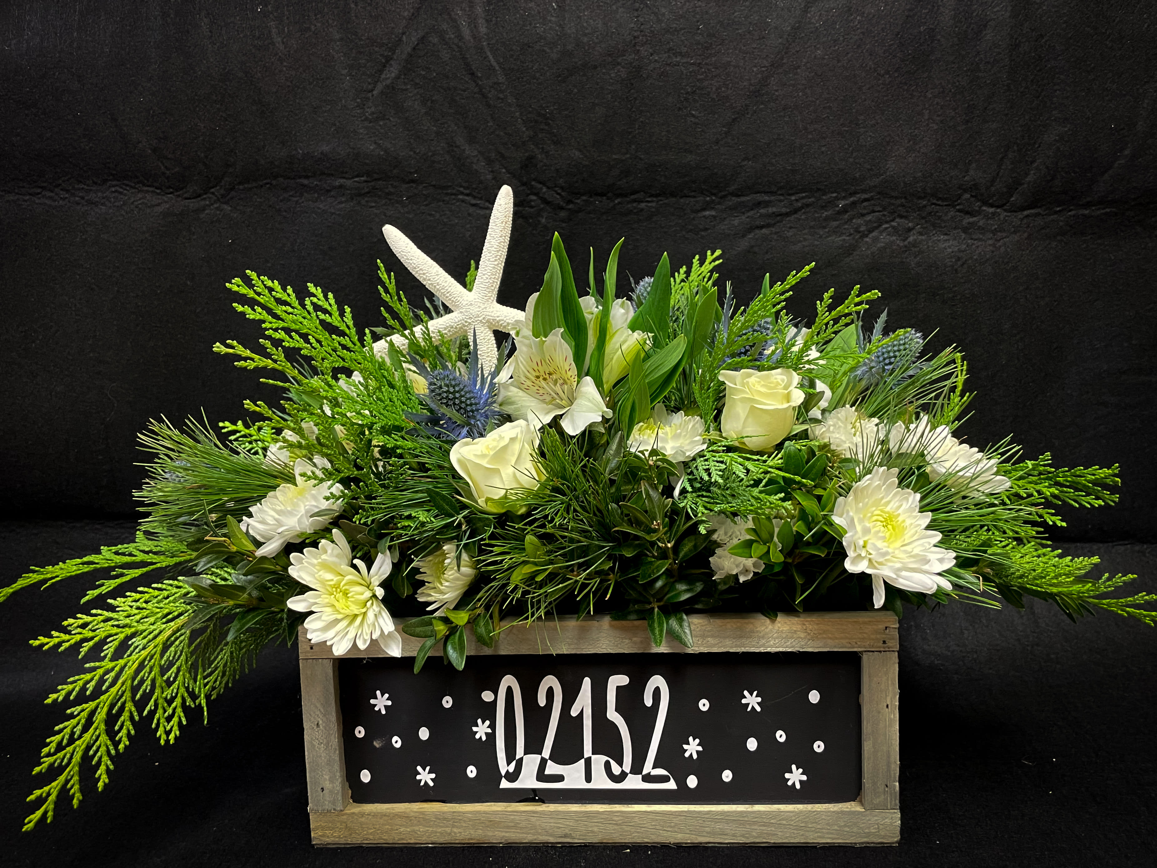 Winthrop Wonderland - A complimentary mix of white blooms and blue thistle come together to bring Winthrop’s shore to your table this holiday season. 