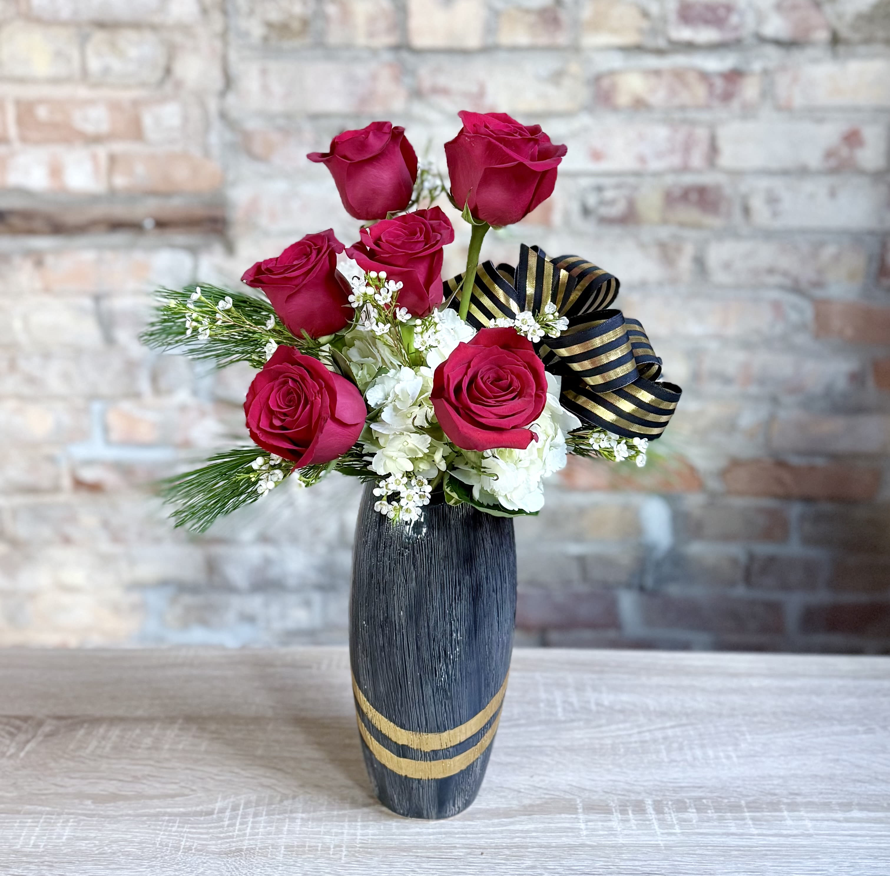 Mary Carolyn  - A modern take on a half dozen roses with winter greens. 