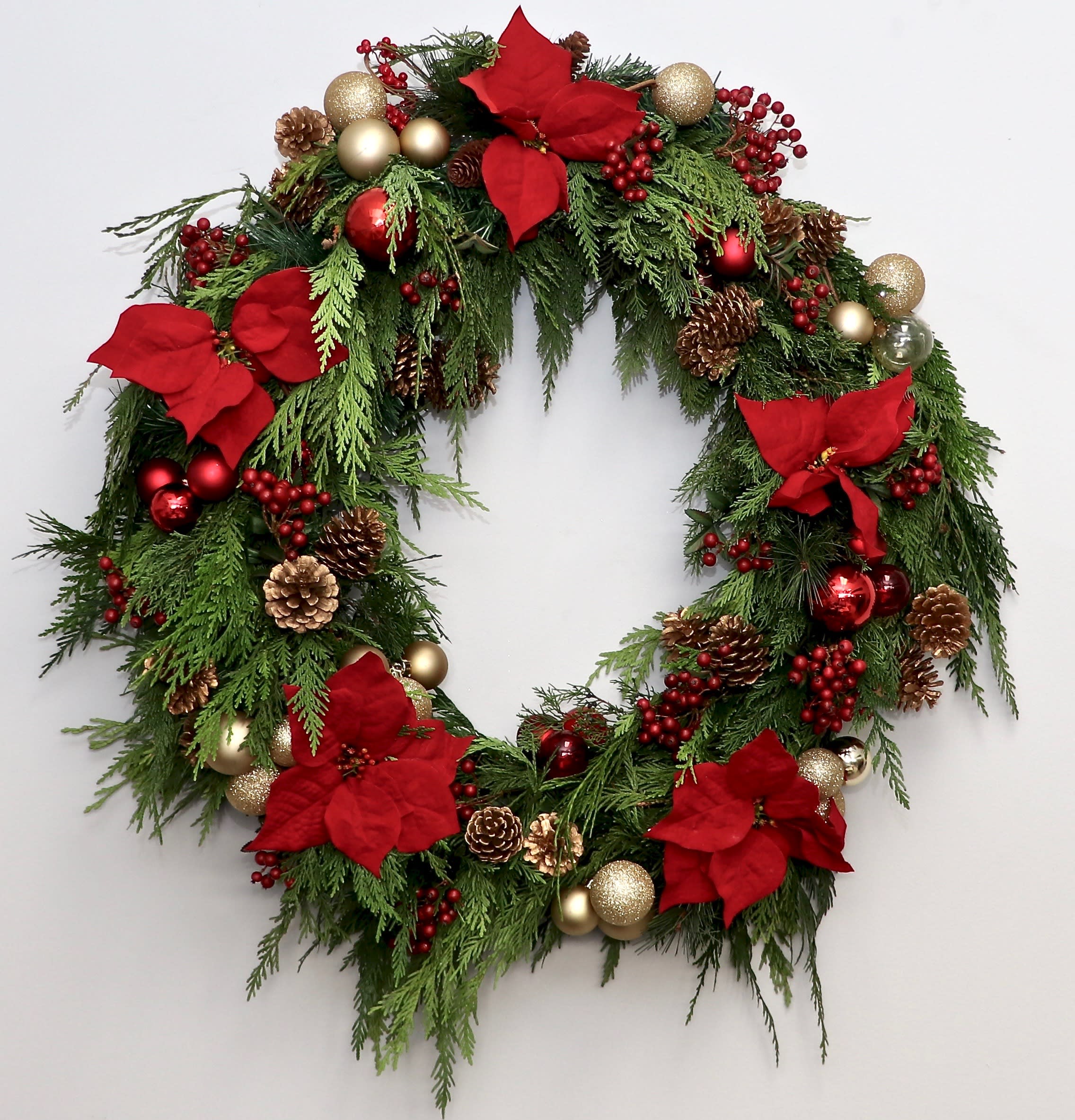 Christmas Wreath - My Glendale Florist  - Decked out for the holidays, this wreath of fir, poinsettias and ornaments will make the statement you're looking for this season.   Standard size is approximately 30 inches wide, Deluxe is 36 inches wide, and Premium is 40 inches wide.