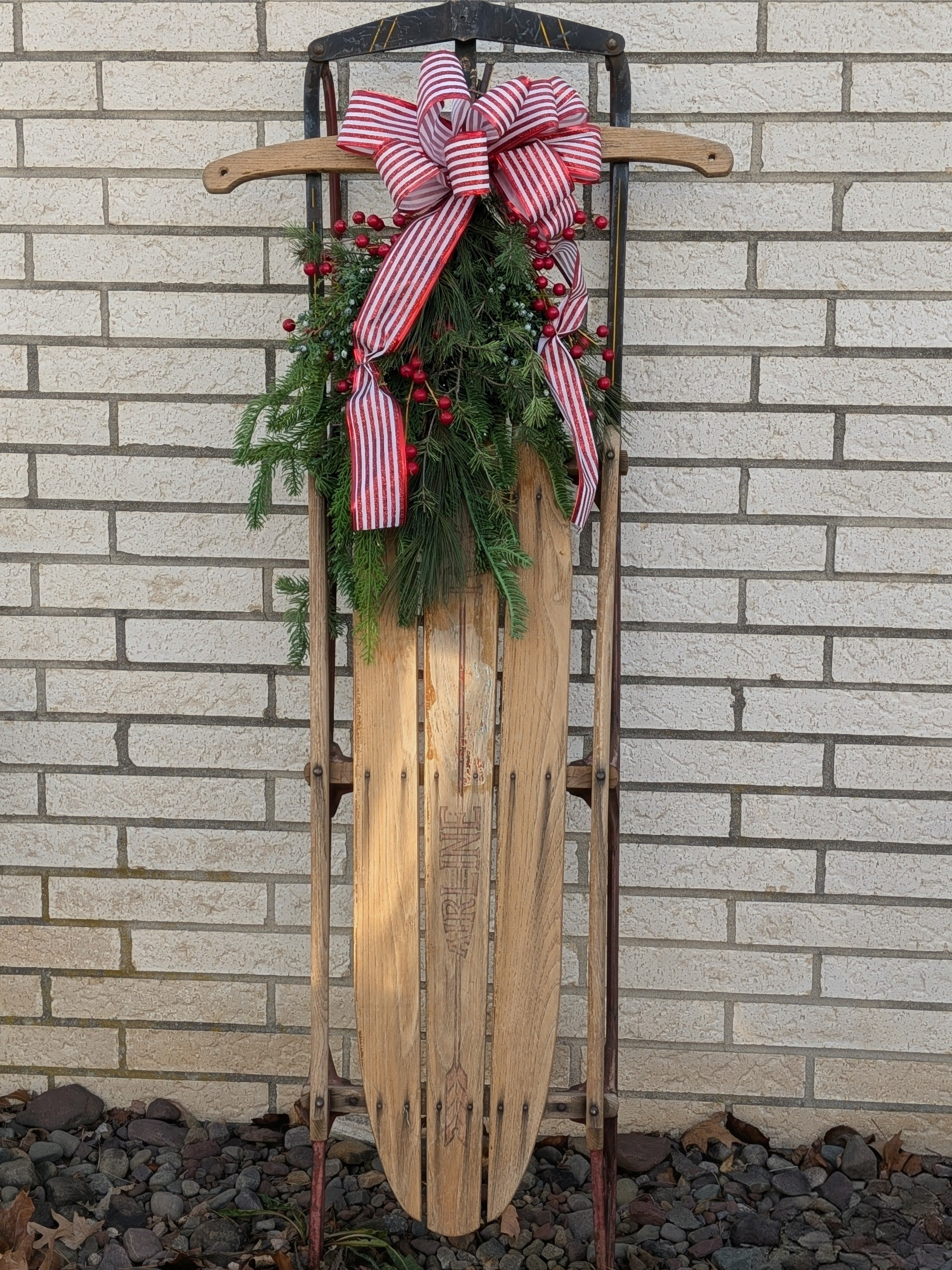 Vintage Christmas Sled  - A real vintage sled with assorted artificial Christmas greens berries and a bow.