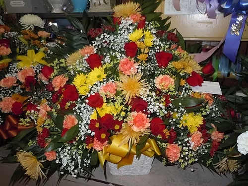 TB28 Sympathy Basket - A mixture of yellow and red daisies, orange carnations, red roses, yellow fuji mums, baby's breath, greens and gold yellow bow  Banner - $15.00 + extra  Substitutions may apply due to flower availability