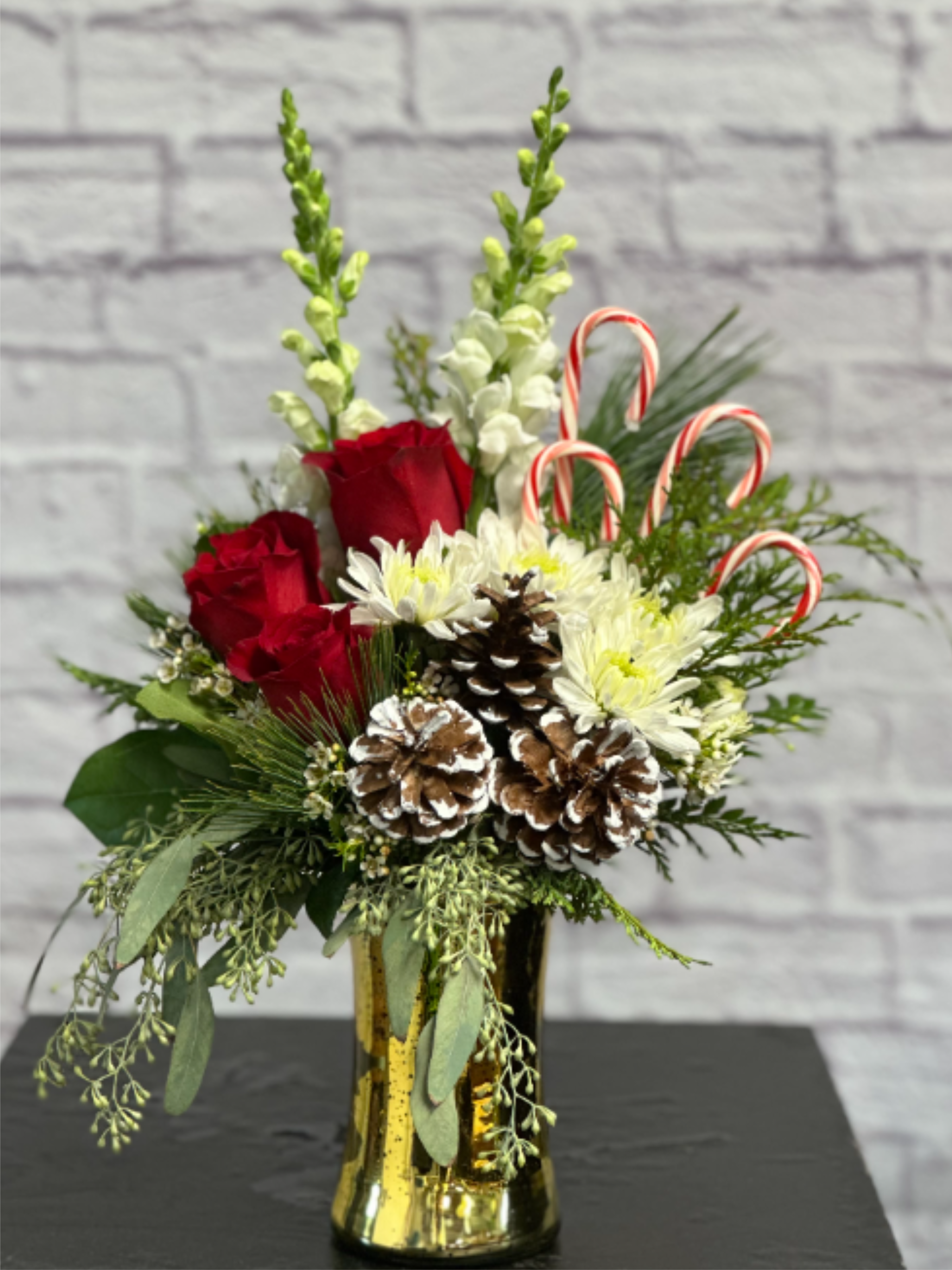 Classic Christmas - Just as it says, a Classic Christmas arrangement with all of your Christmas favorites! Evergreen, red roses, pine cones and candy canes!