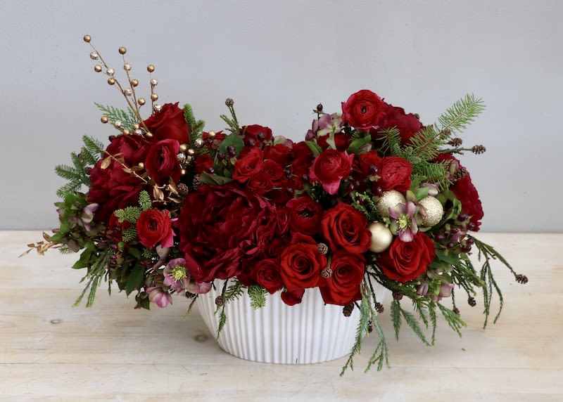 Santa's Red Garden - Weho  - This arrangement mixes together peonies, ranunculus, and roses all in the shade red in a white ceramic vase. The photo shown is in the standard size, don't forget to upgrade for more blooms!  