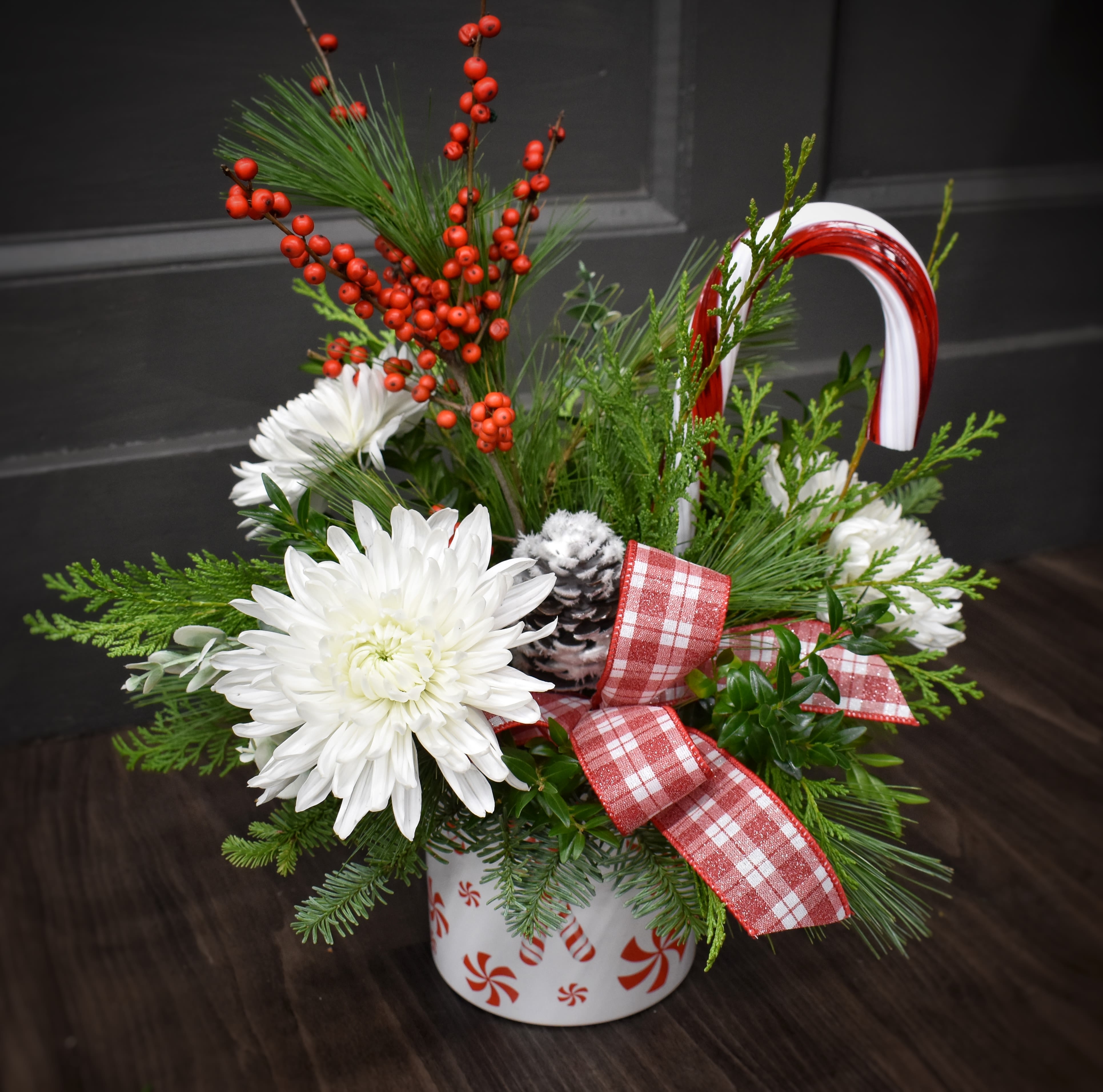Deluxe Winter Mint  - Freshen your home with this minty delight! This peppermint printed keepsake container is filled with a fragrant mix of winter greens, a flocked pinecone, red berries, a candy cane, white Cremon mums and finished with matching ribbon. 