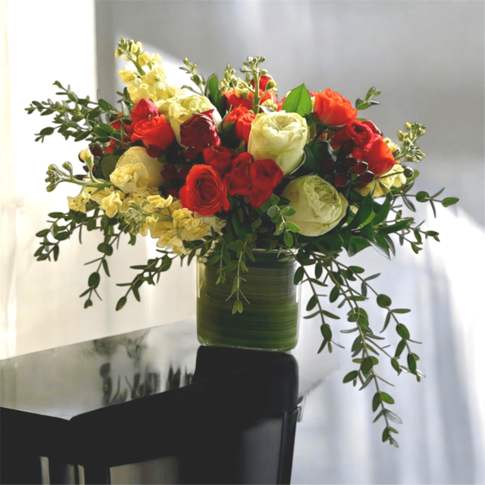 Festive Fall - A beautiful mix of roses, ranunculus, eucalyptus, and more in warm fall colors. This makes a lovely addition to any Thanksgiving table or as a hostess gift. 