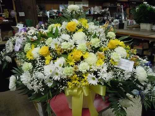 TB36 Sympathy Basket - A mixture of white and yellow daisies, green carnations, yellow roses, white fuji mums, yellow alstromaria,baby's breath, greens and lavender bow  Banner - $15.00 + extra  Substitutions may apply due to flower availability