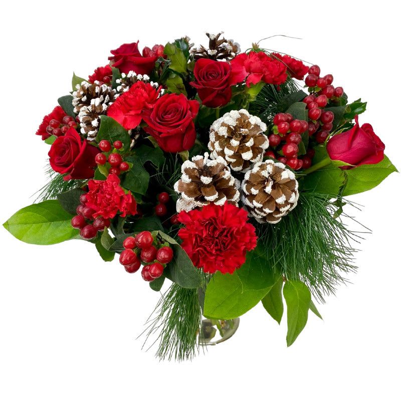 Christmas Time - A Christmas arrangement with red roses, red carnations, pine branches, Red Berries and holiday decorations, beautifully displayed in a vase.