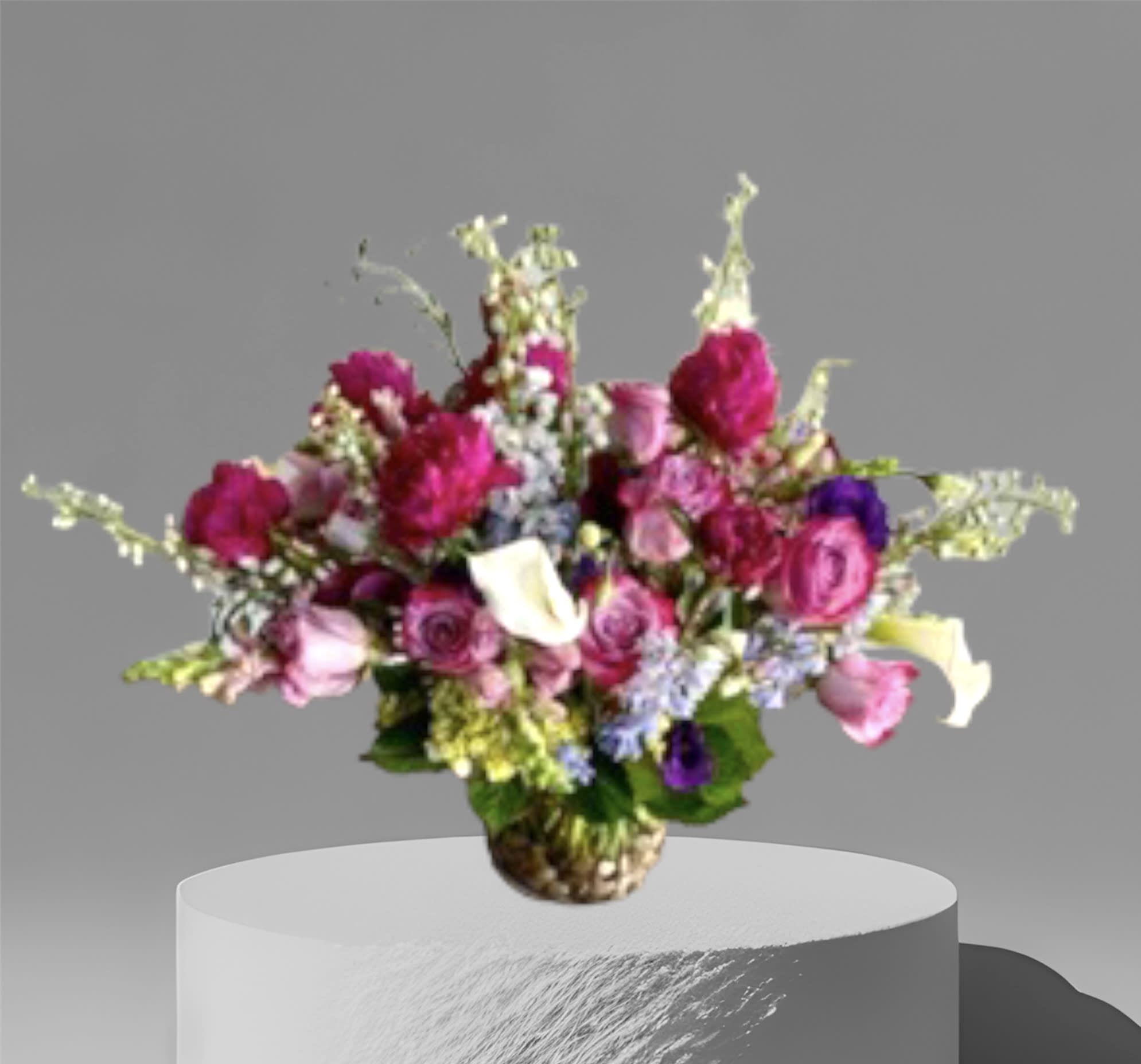 Sugar Plum Fairy - Pinks and purples surrounded by seasonal foliage and flowers in a glass cylinder vase with decorative river rocks.    