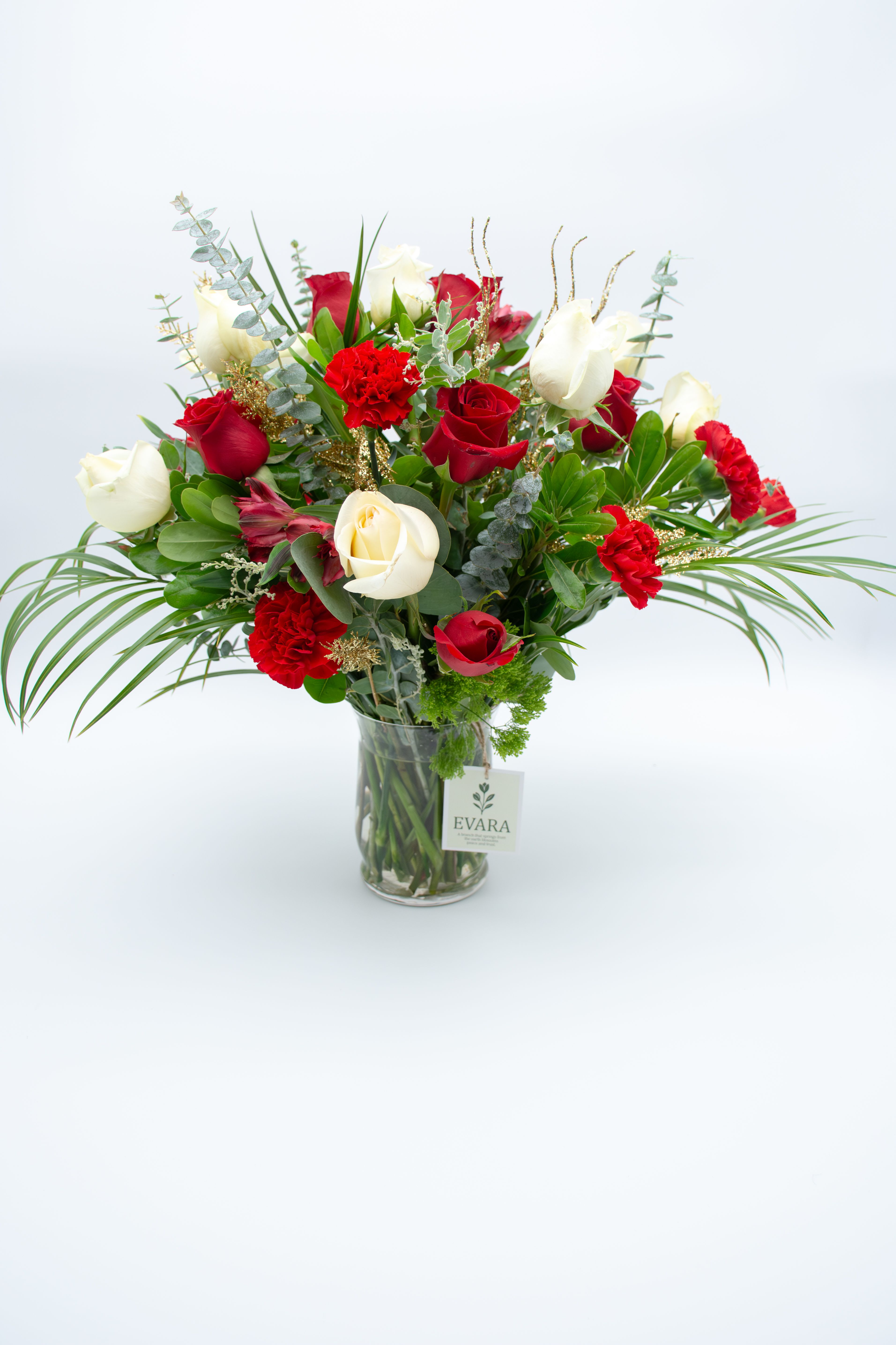 Royal Christmas.       - An elegant holiday arrangement featuring premium red and white roses, scarlet carnations, touches of alstroemeria, and festive golden branches that add sparkle and sophistication.