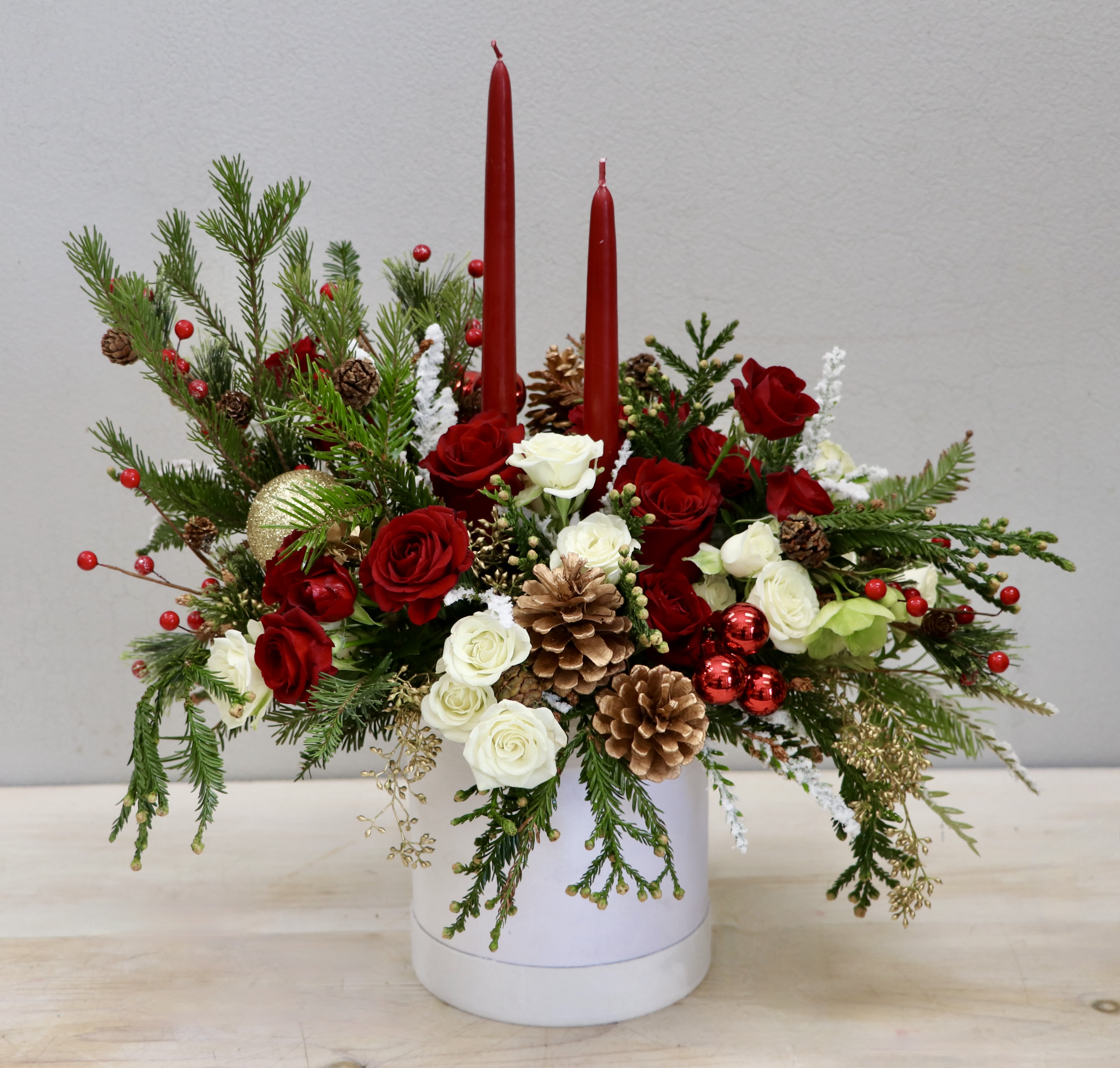 A Very Merry Radiance - Weho  - Start the year right with beautiful blooms in your home! This centerpiece has a mix of roses, holiday decore and seasonal greenery perfect for the holidays. Be sure to upgrade for more blooms!
