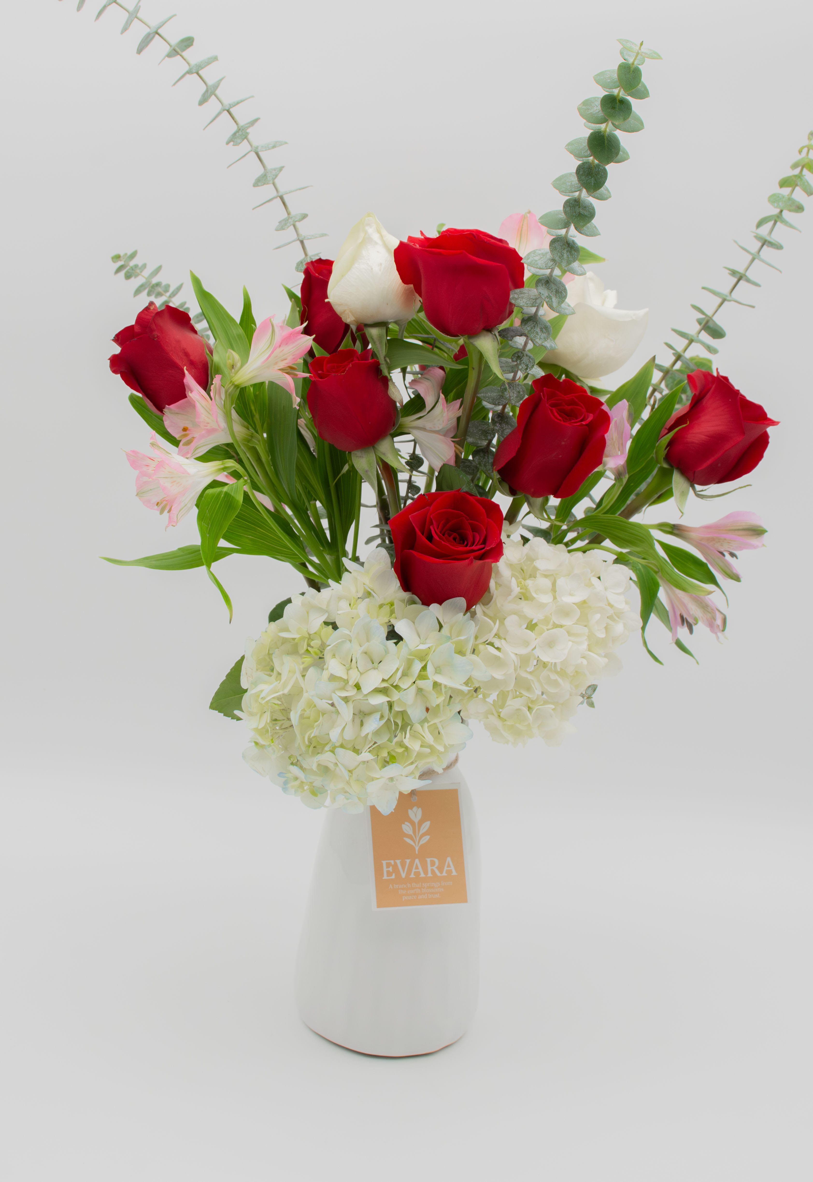 Classic Love - An elegant and timeless arrangement combining premium red roses, white roses, pink alstroemerias, and a white hydrangea base.