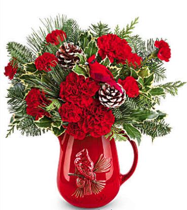 Scarlet Melody Bouquet - Teleflora's Scarlet Melody Bouquet hits a high note with bold red carnations and festive evergreens in Teleflora's Scarlet Cardinal Pitcher. A charming gift or centerpiece that sings with holiday spirit.  Features red carnations and red miniature carnations. Accented with cedar, variegated holly, noble fir, and white pine, all arranged in Teleflora's Scarlet Cardinal Pitcher (while supplies last).