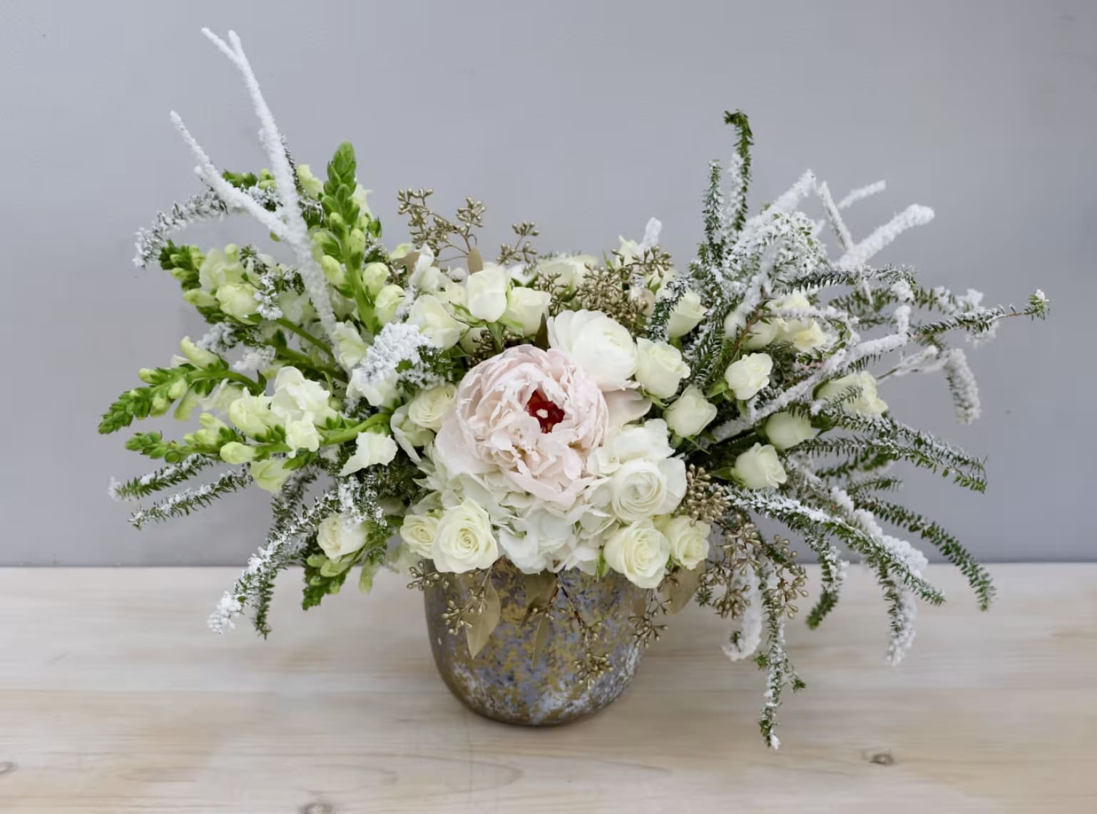 Winter's First Snow - Weho  - A faux-snow covered vision, as stunning as a frosted winter landscape. White peonies rest on hydragneas along with snap dragons and roses. It stands approx 16'' tall