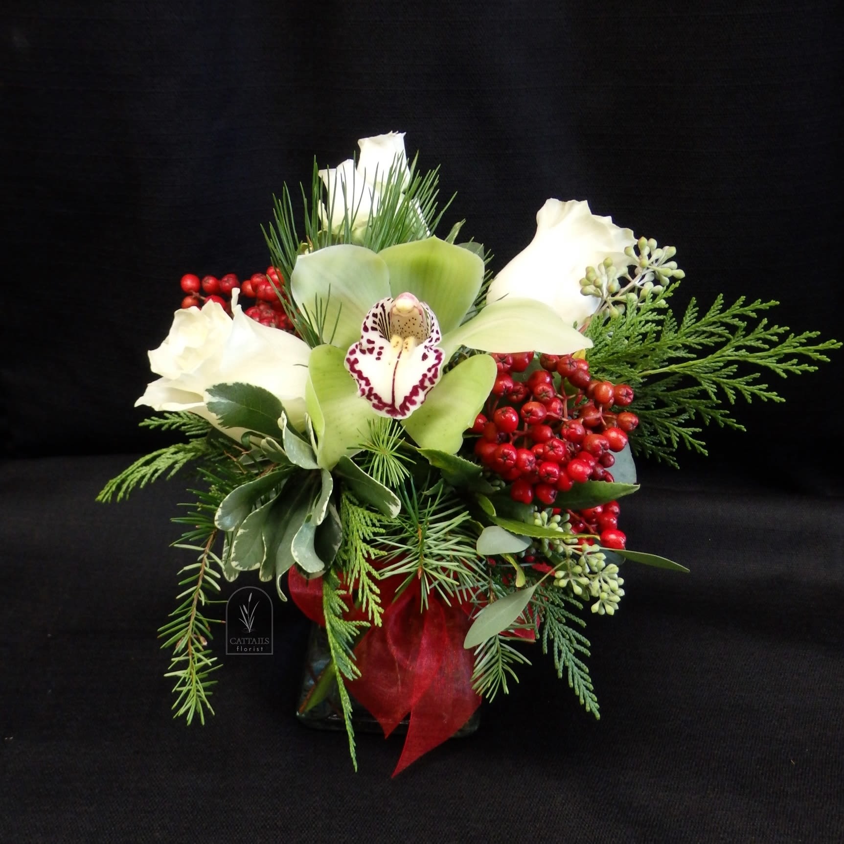 Jingle Berry - Mini Vase Christmas arrangement with all the perfect touches! Cymbidium Orchids, Berries, and Roses